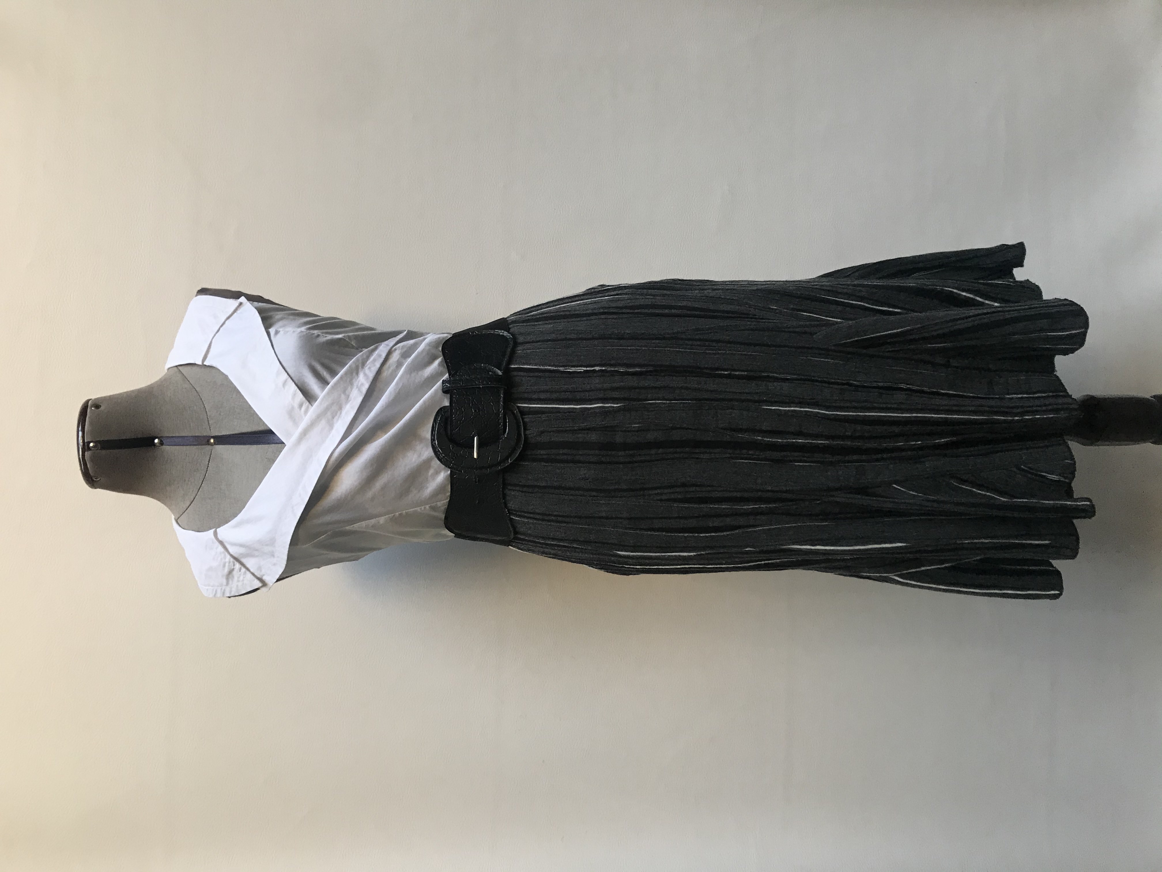 Falda midi Opera color plomo con textura de líneas negras y blancas, cierre lateral y godets con vuelo en la basta
Talla M grande (pretina 80cm)
