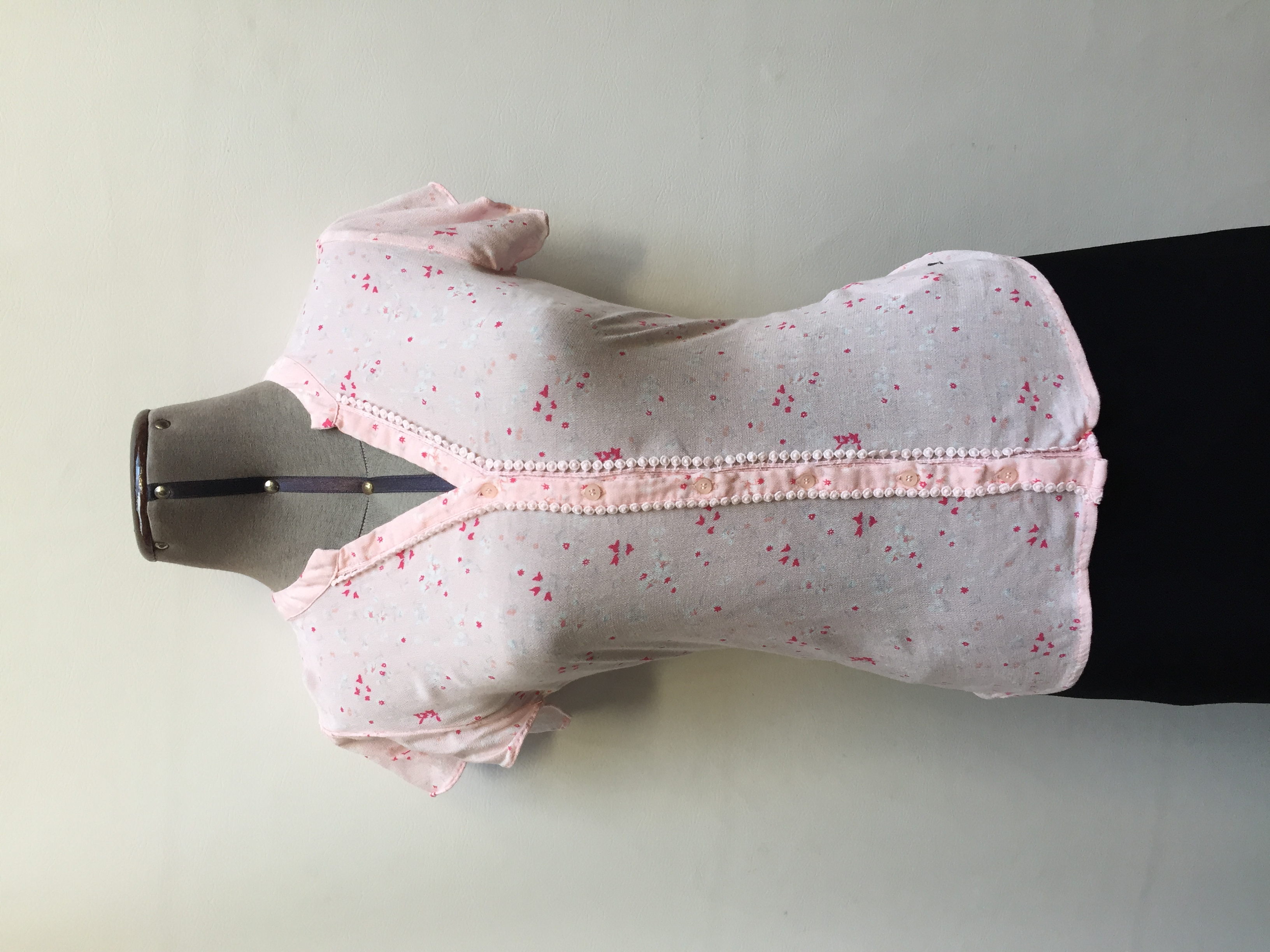 Blusa Aeropostale rosada con estampado de flores blancas y rosadas, escote en V con blondas, botones en el centro y manga corta
Talla S