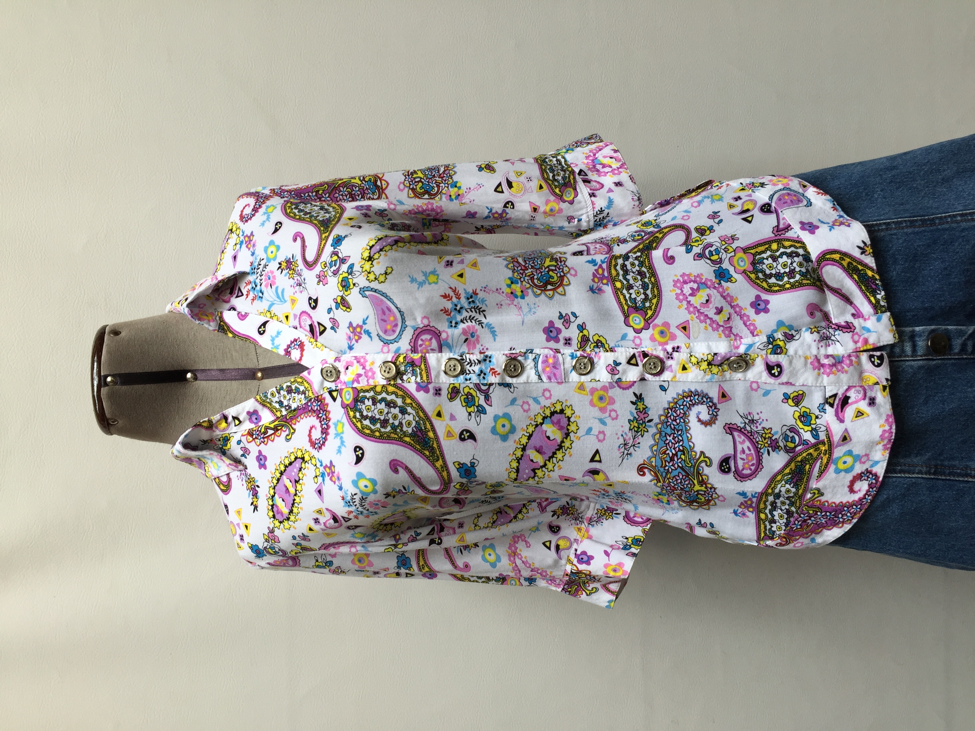 Blusa blanca con estampado de colores paisley, cuello camisero con fila de botones y manga 3/4. Tela fresca!
Talla S