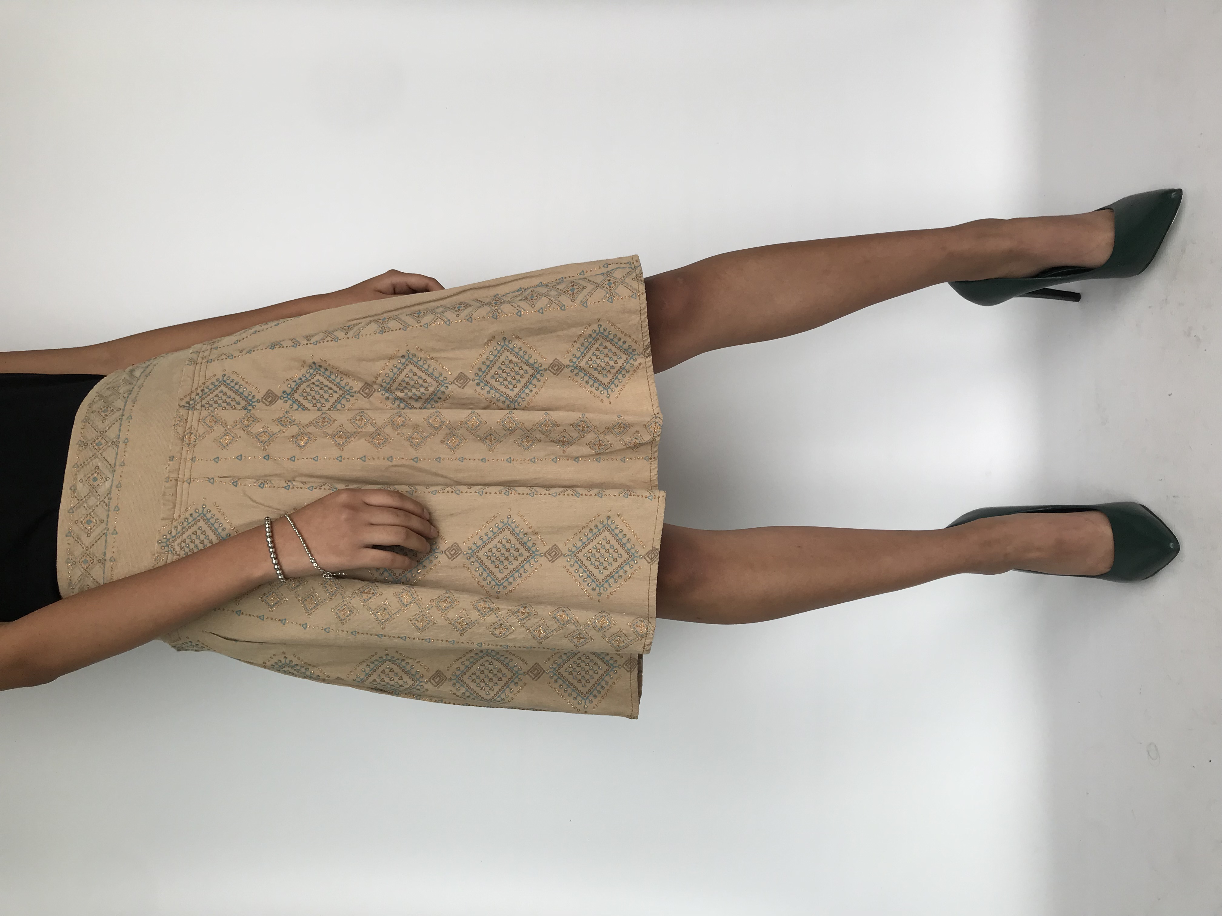 Falda tipo corduroy beige con estampado escarchado tribal, pretina ancha y tableada, cierre y botón lateral. Cintura 74cm Largo 59cm