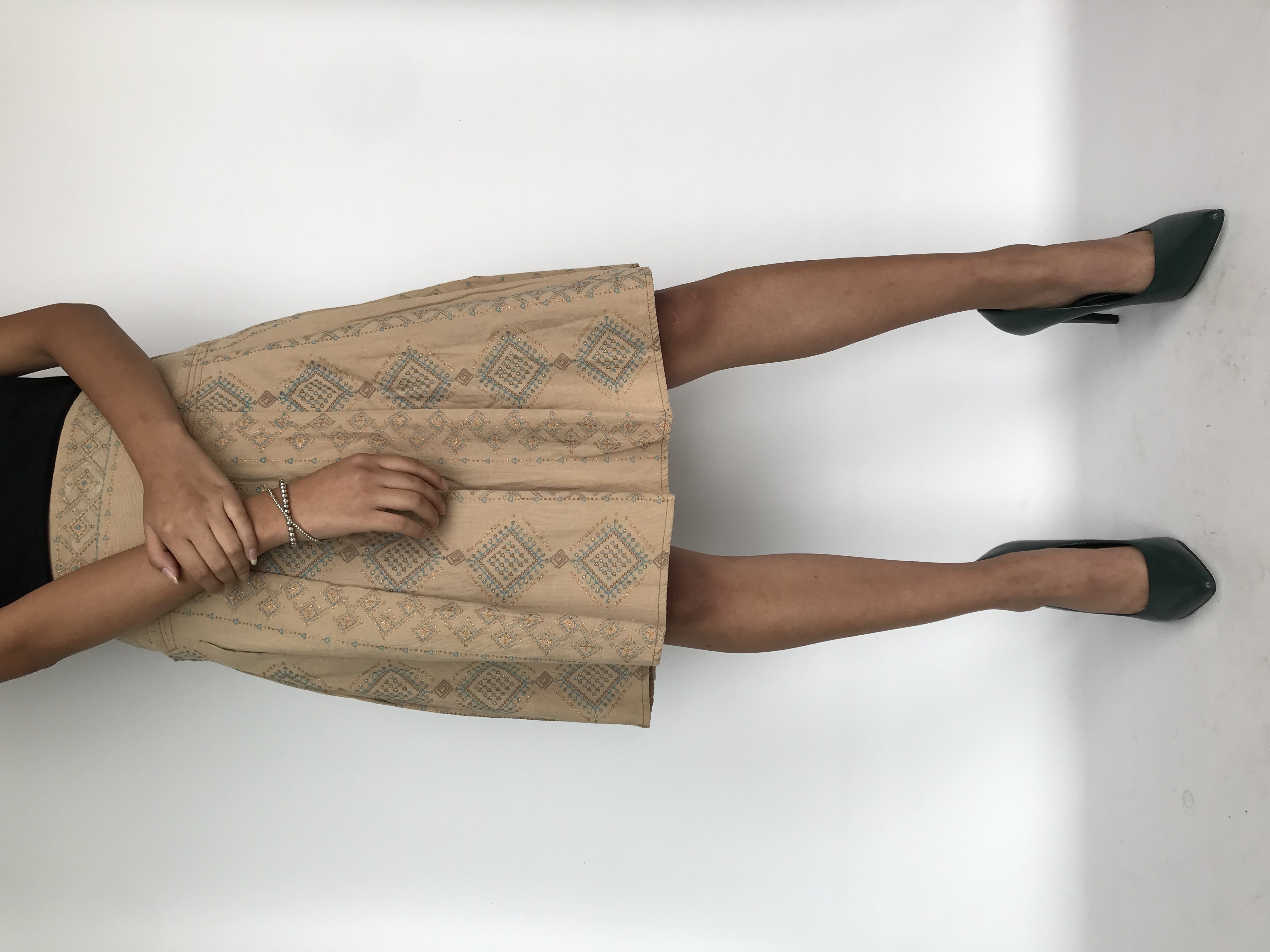 Falda tipo corduroy beige con estampado escarchado tribal, pretina ancha y tableada, cierre y botón lateral. Cintura 74cm Largo 59cm