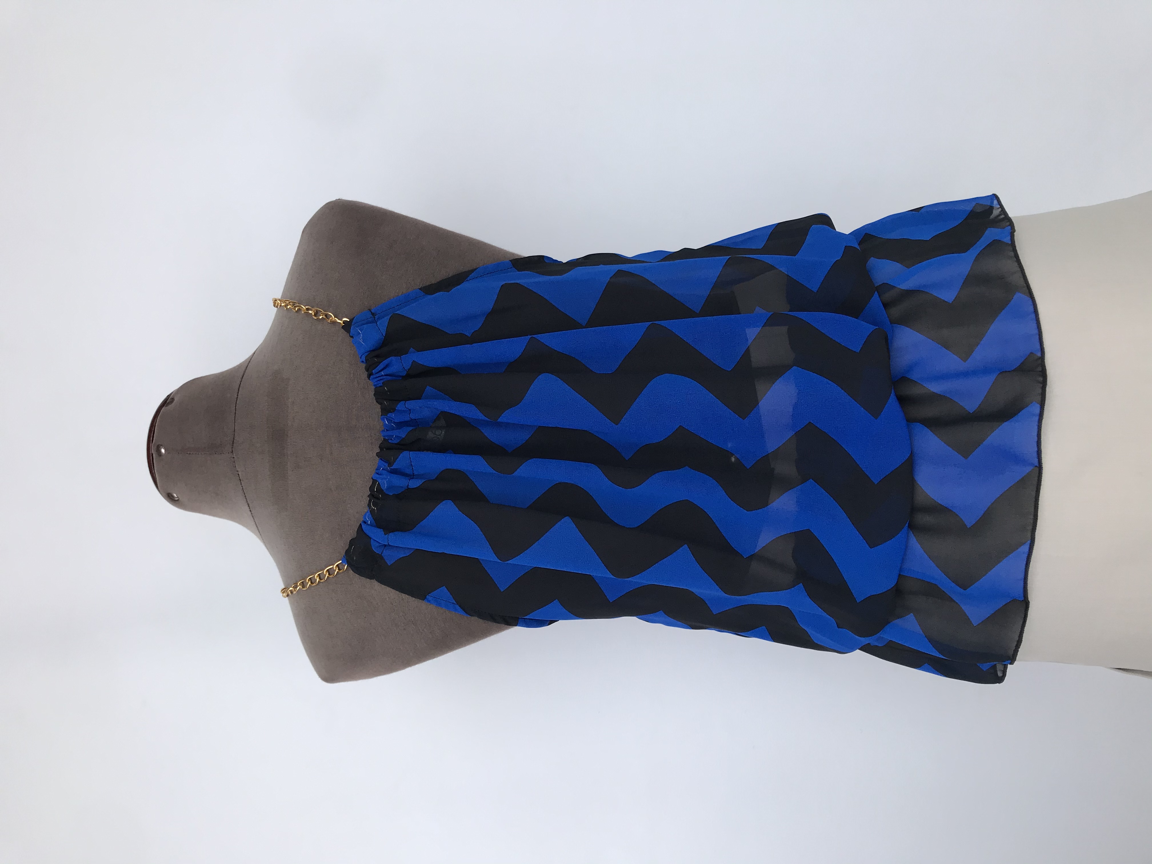 Blusa de gasa con estampado zigzag azul y negro, cuello recogido con cadena dorada, elástico en la basta. Largo desde cuello 52cm