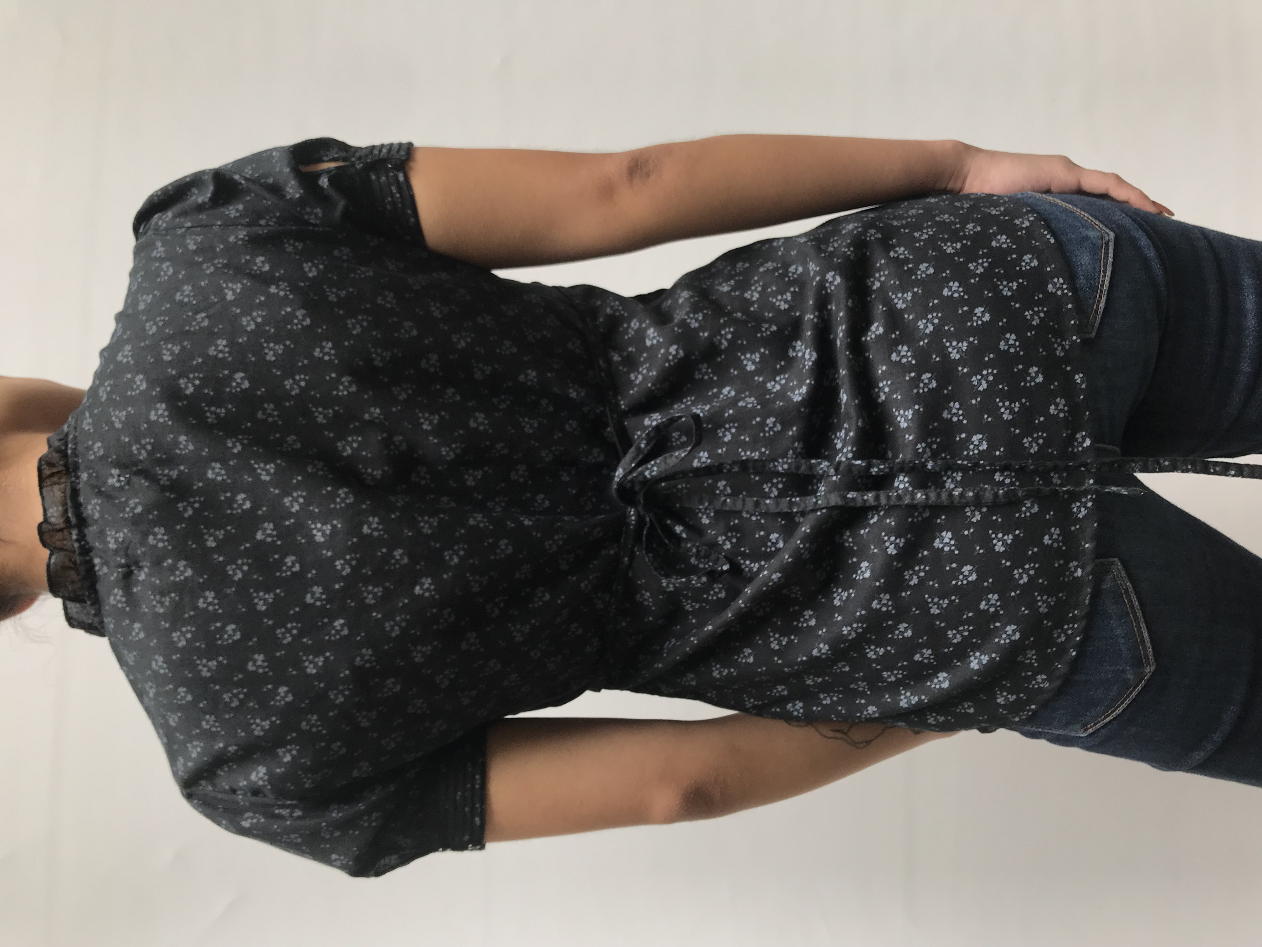 Blusa Aeropostale negra con estampado de flores grises, escote en V con pliegues, botones y bobos en el pecho, tira para regular la cintura
Talla S