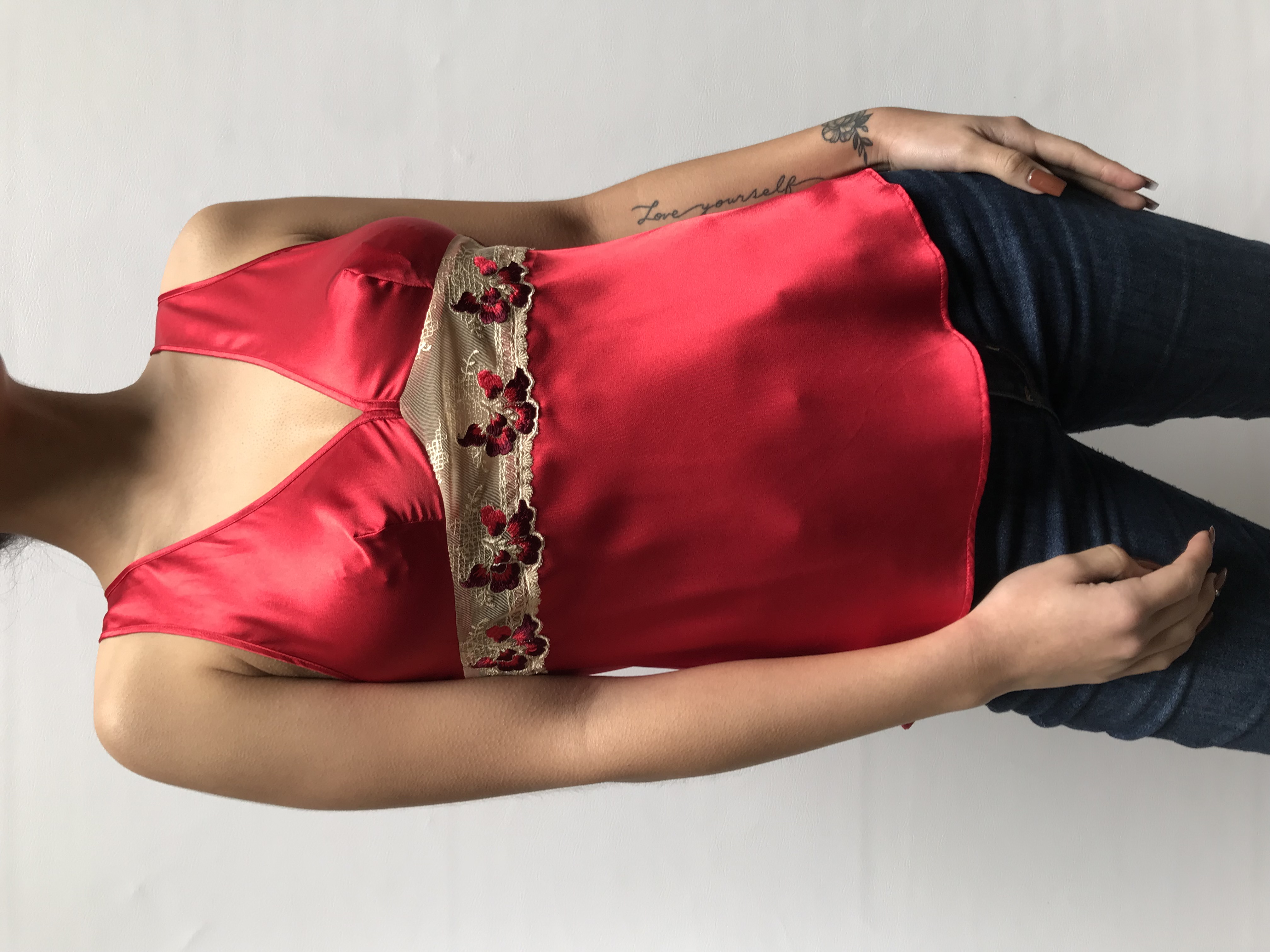 Blusa roja de raso, con escote en V, detalle de  encaje y bordado de bajo del busto.
Talla XS/S