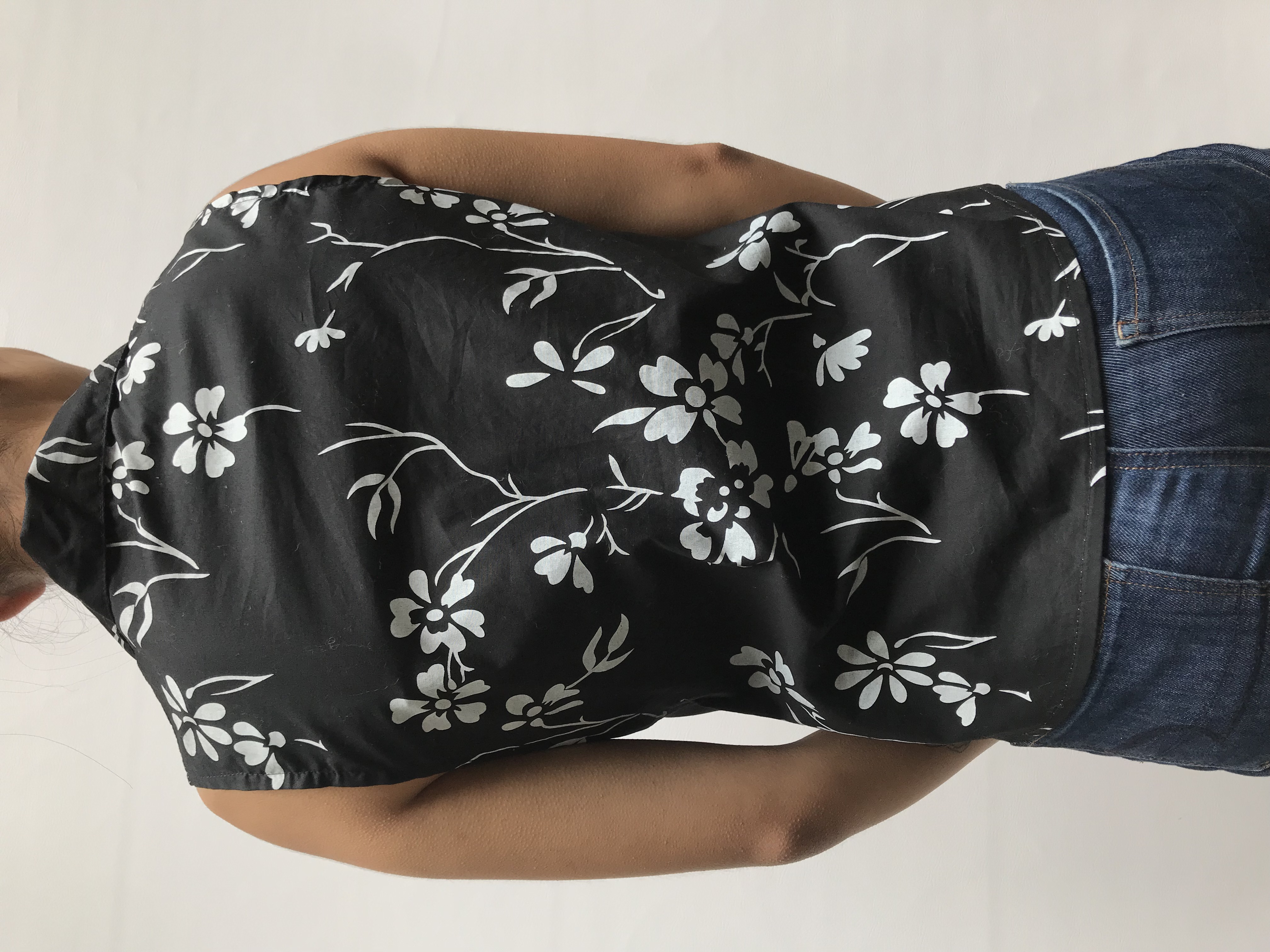 Blusa negra con estampado de flores blancas, cuello camisero, escote en V y fila de botones
Talla M