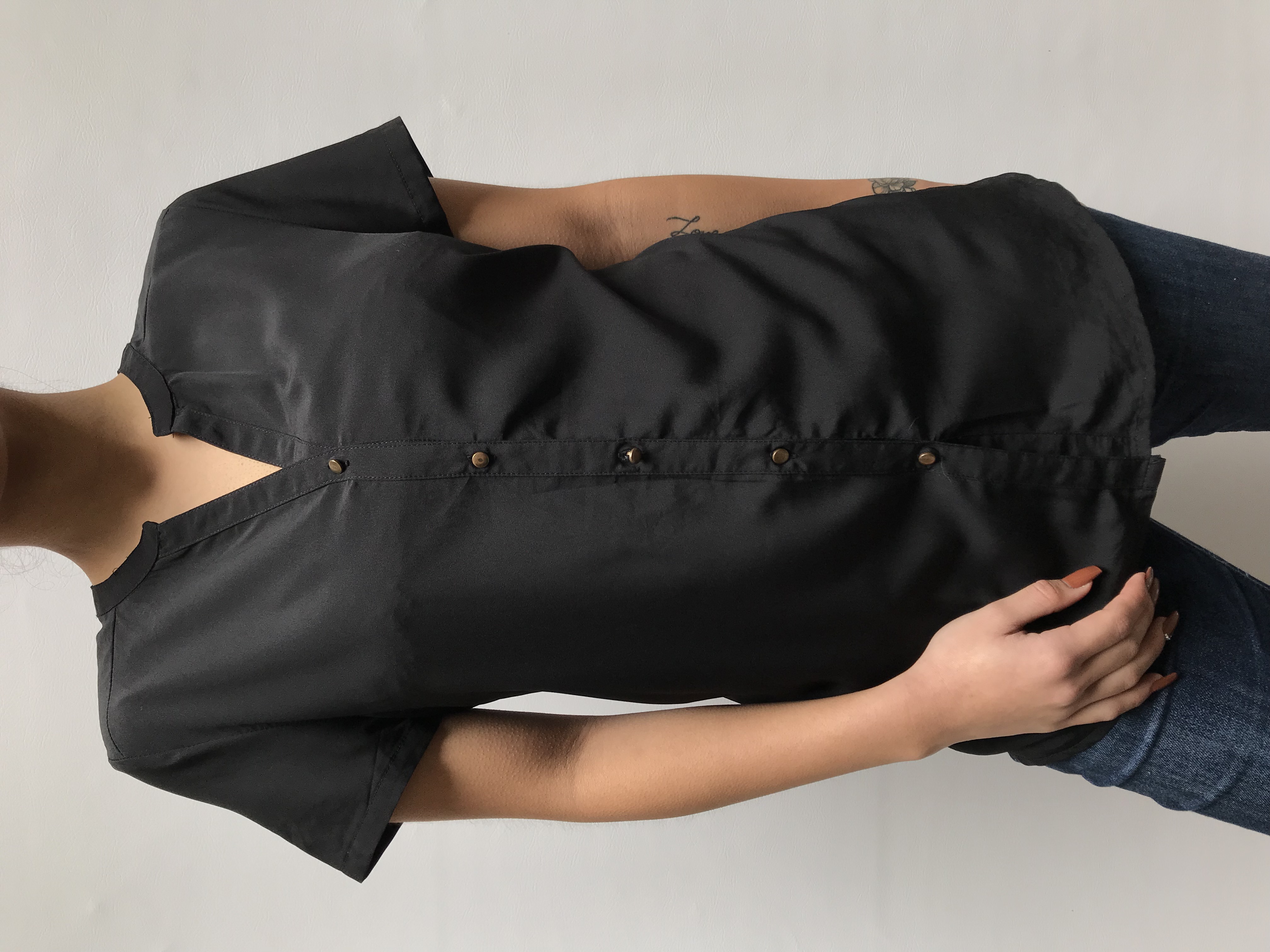 Blusa tela plana negra con botones en tono bronce. Busto 98cm Largo 65cm