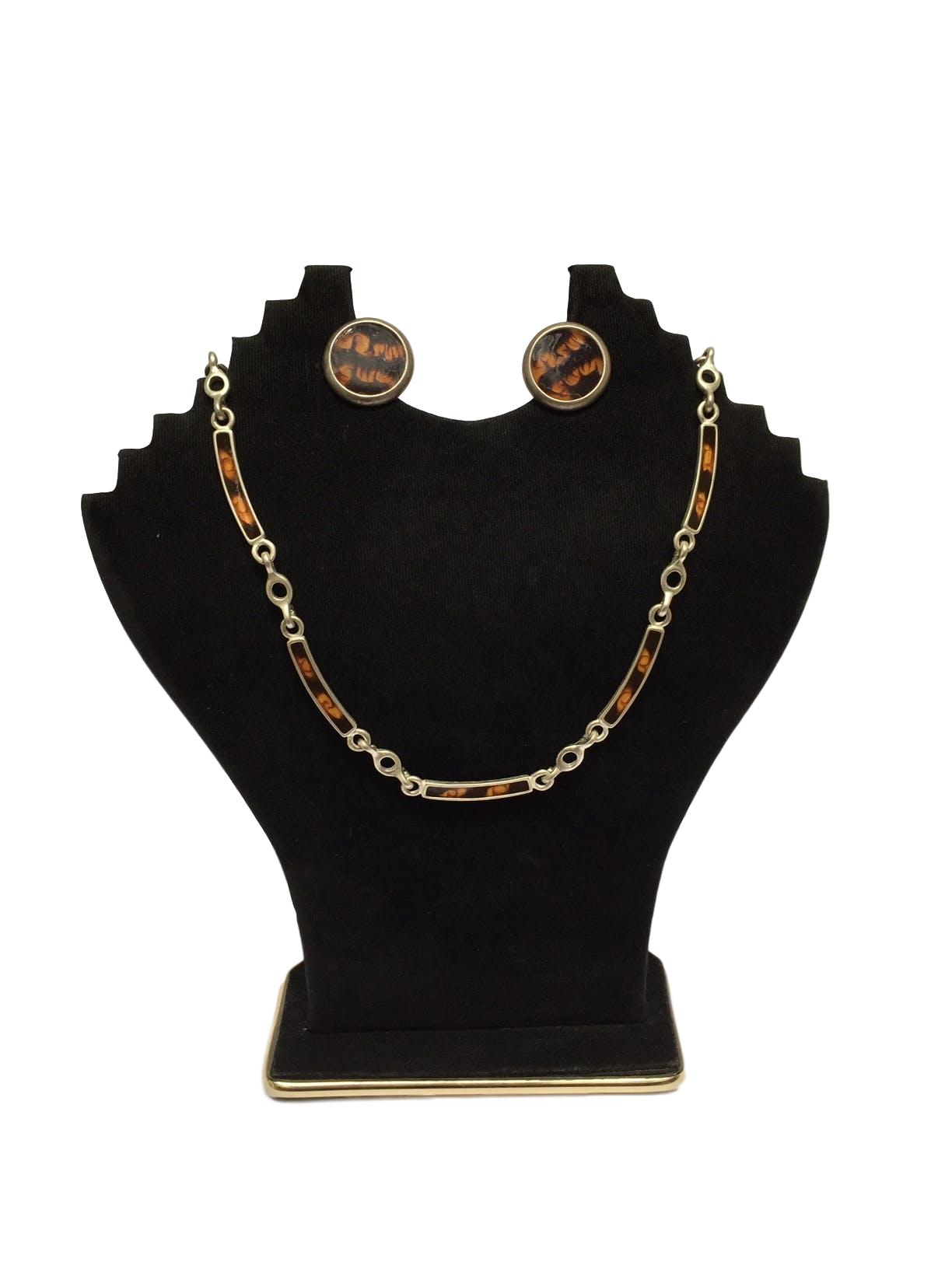 Collar plateado con rectángulos en tonos marrones e intersecciones circulares
Circunferencia: 46 cm