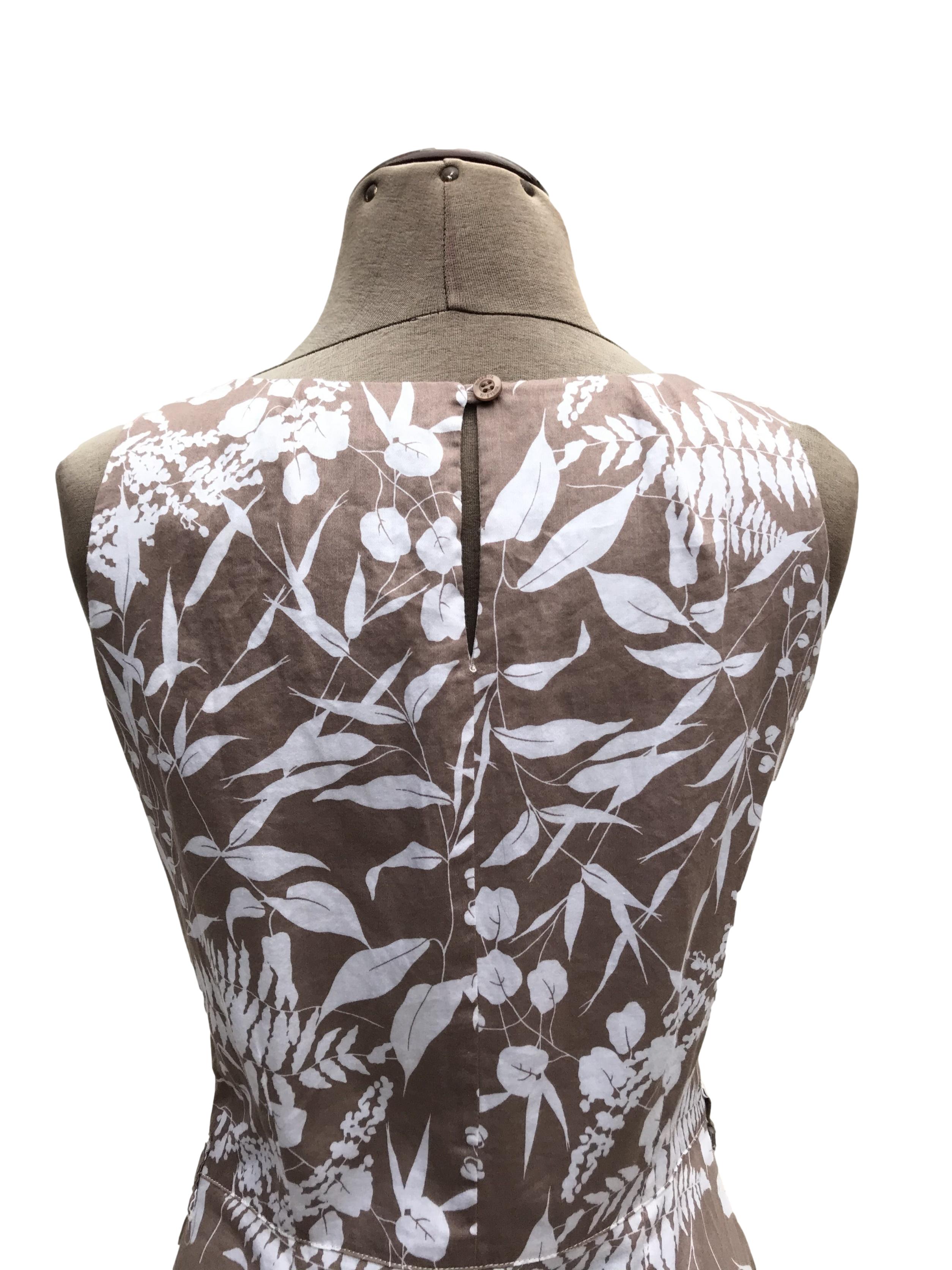 Vestido Moda&cia marrón claro con estampado de flores blancas, 97% algodón, forrado en el torso, botón posterior en el cuello, cierre lateral y bolsillos. Largo 91cm. Precio original S/ 250