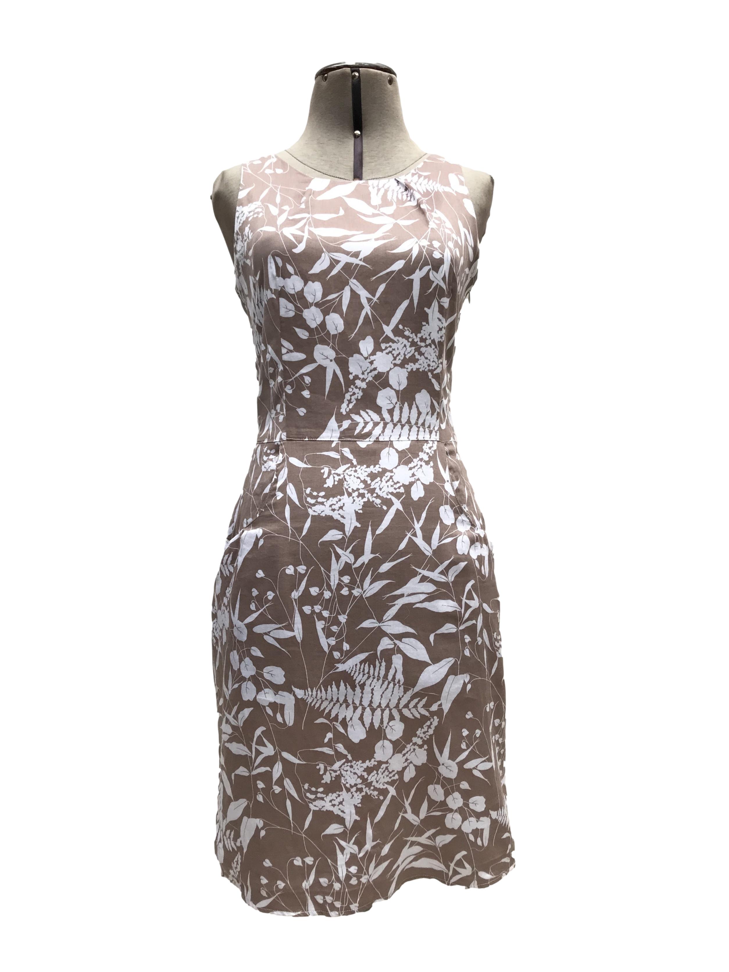 Vestido Moda&cia marrón claro con estampado de flores blancas, 97% algodón, forrado en el torso, botón posterior en el cuello, cierre lateral y bolsillos. Largo 91cm. Precio original S/ 250