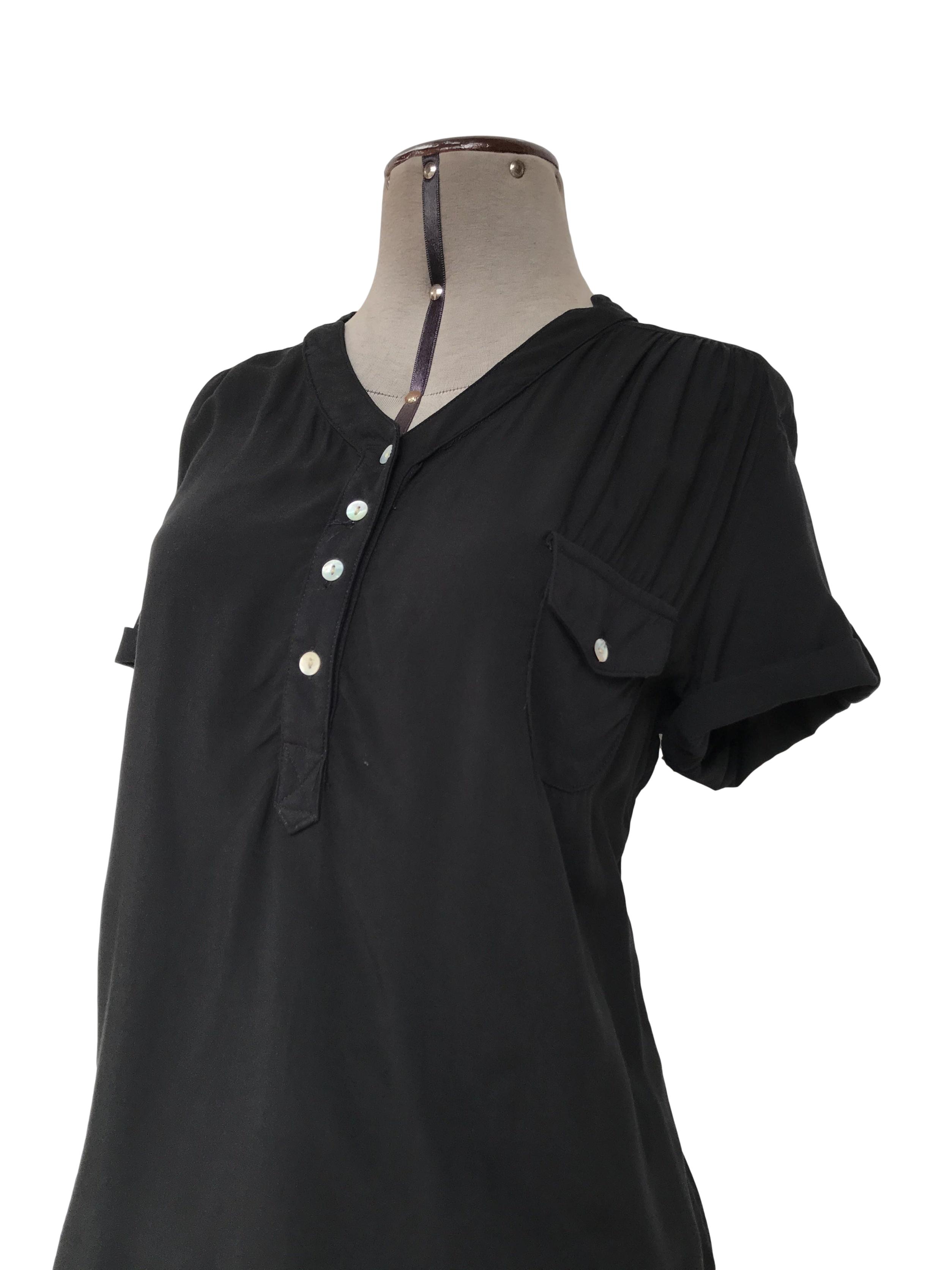 Blusa negra de tela fresca tipo chalis, botones nacarados en el escote, bolsillo y mangas regulables con botón
Talla M