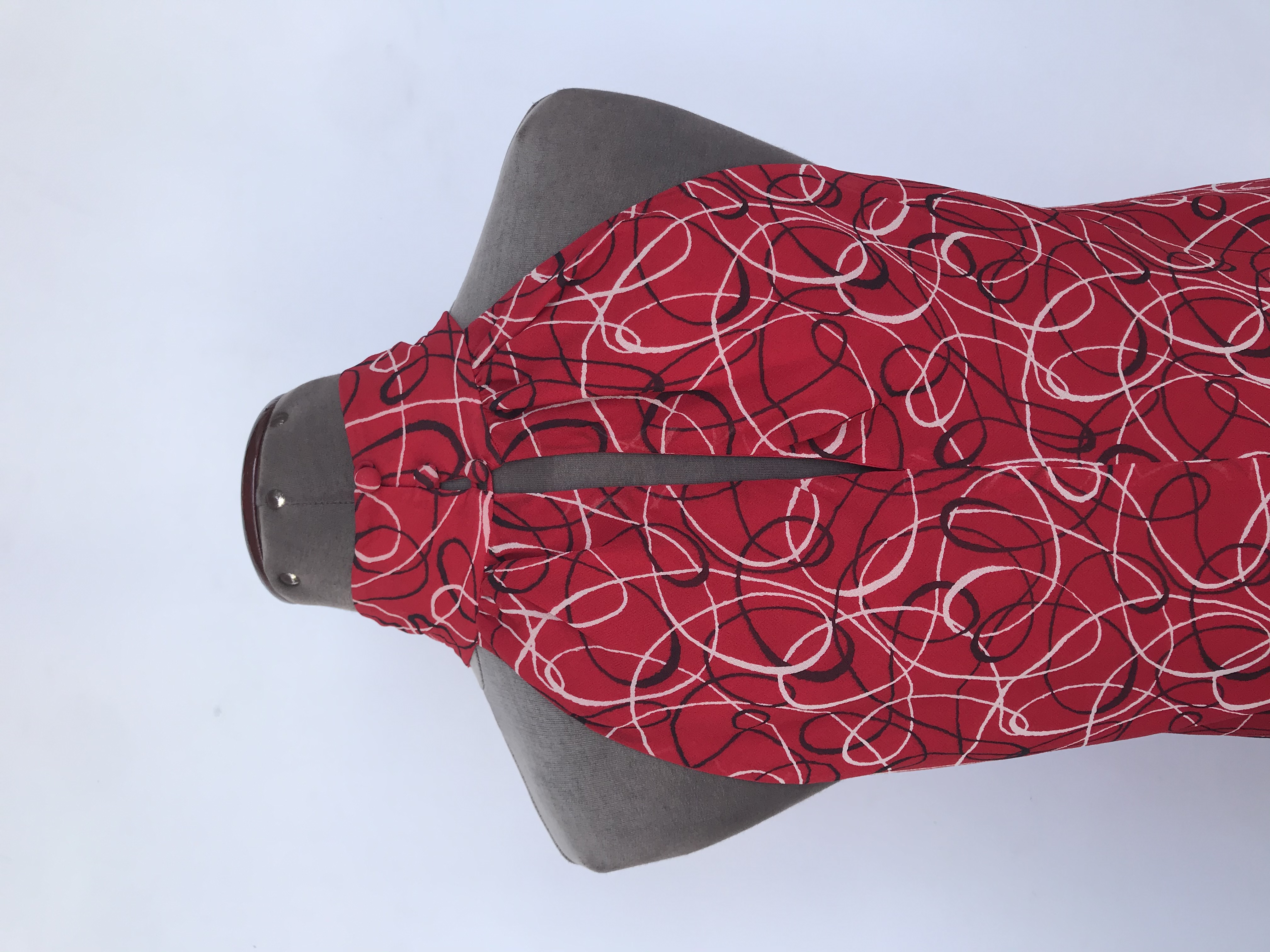 Blusa I.N.C de gasa roja con estampado de espirales crema y negro, cuello alto con botones posteriores, es forrada
Precio Original S/. 180
Talla S (8, Puede ser M)