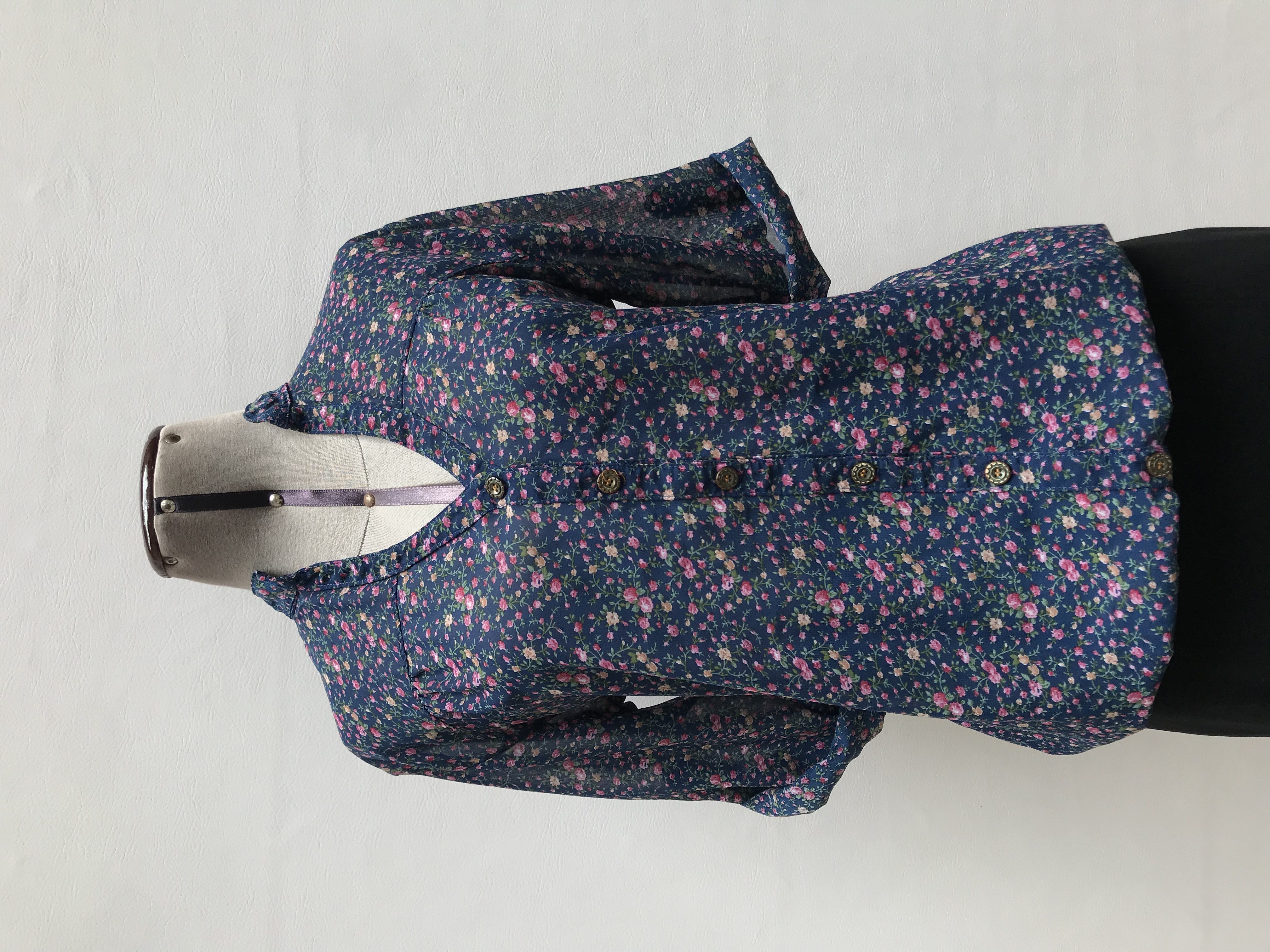 Blusa de gasa azul con estampado de flores, cuello nerú y botones centrales, elástico en la basta, manga 3/4 regulable con botón
Talla M