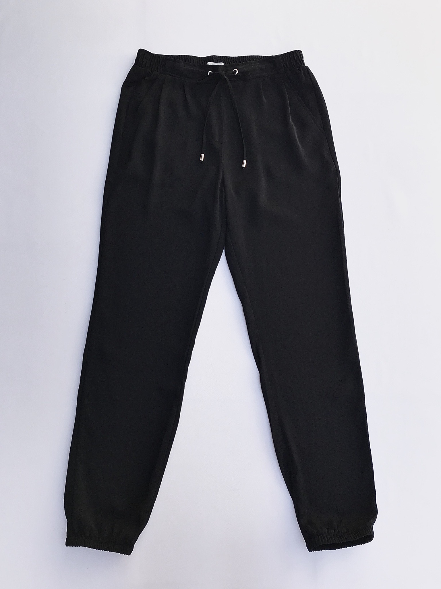 Pantalón Sfera negro, estilo jogger de tela plana, 
 con pinzas delanteras, bolsillos laterales, elástico posterior y en basta, pasador regulable en cintura 
Talla 28