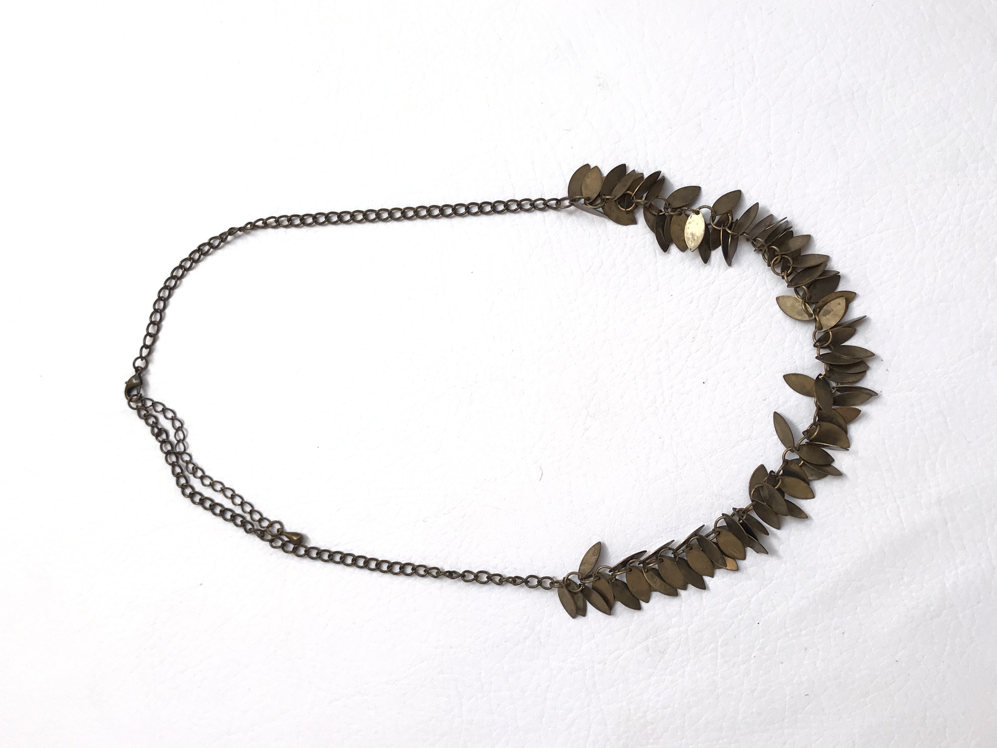 Collar cadena en tono oro viejo, con dijes de pétalos pequeños. Largo 55cm (+7cm regulables)
