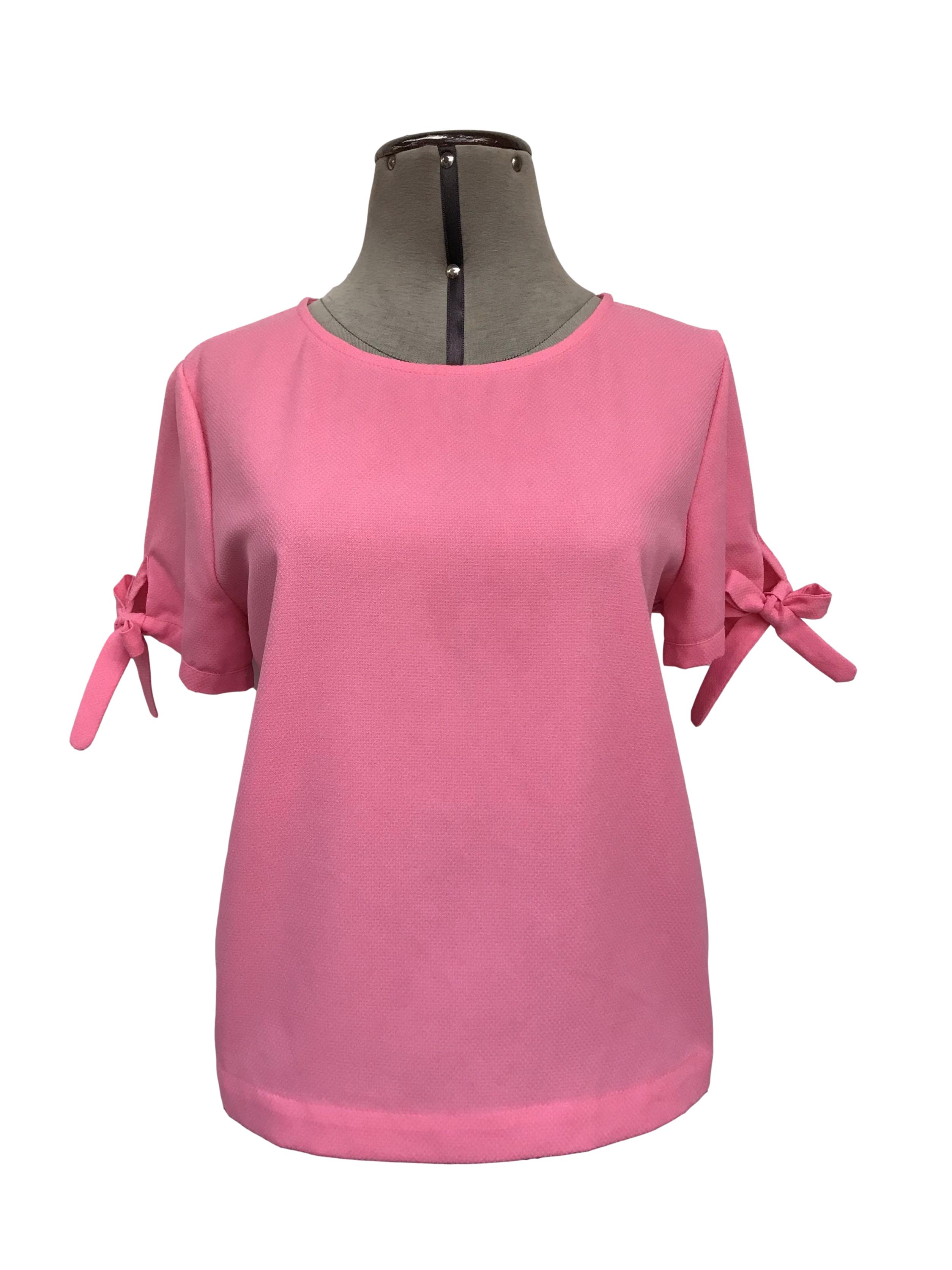Blusa Forever21 rosa con textura tipo crepé, con lacitos para amarrar en las mangas
Talla M