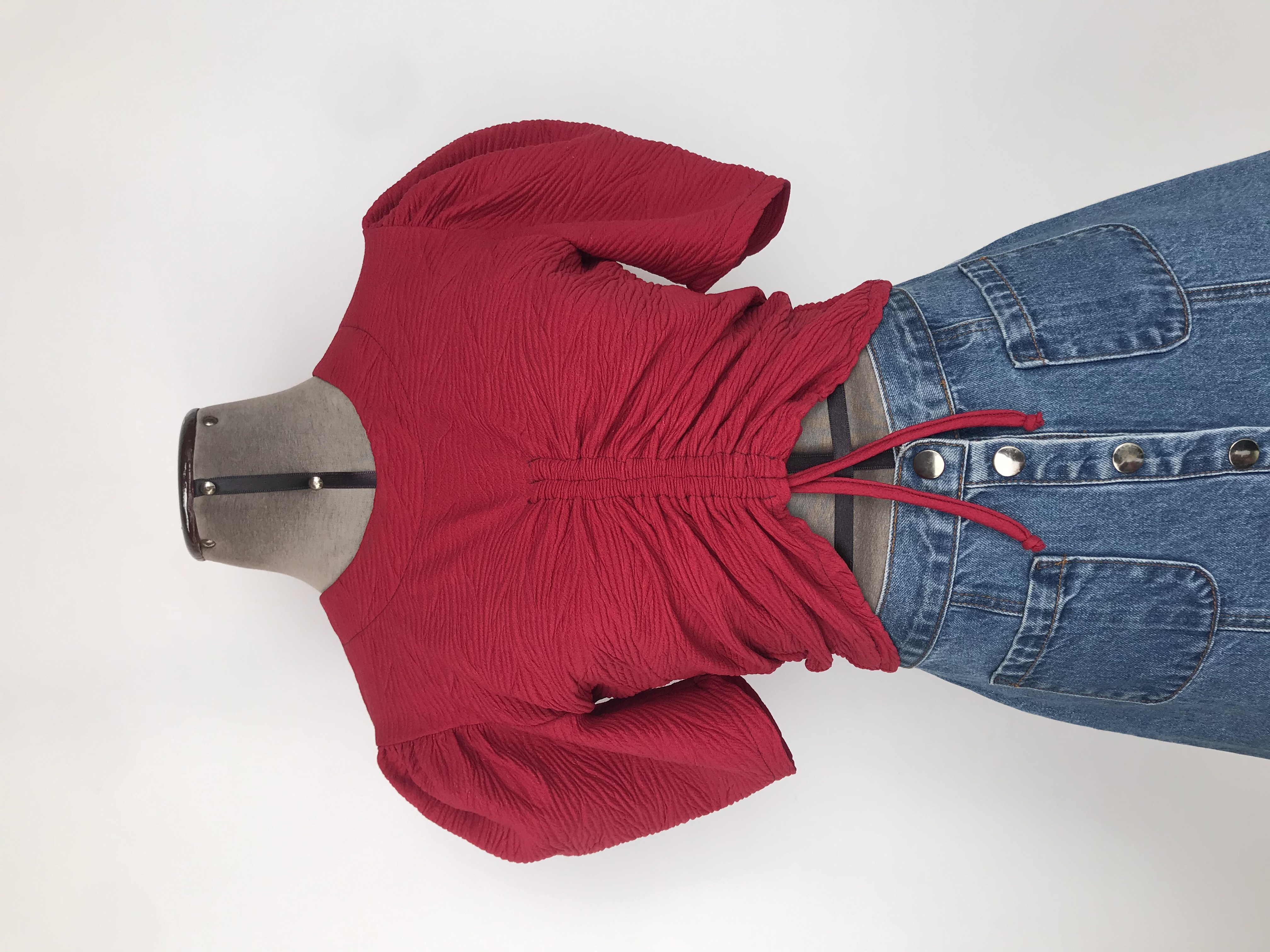 Blusa roja de tela con textura, recogido delantero, botón posterior en el cuello y mangas abuchonadas
Talla S