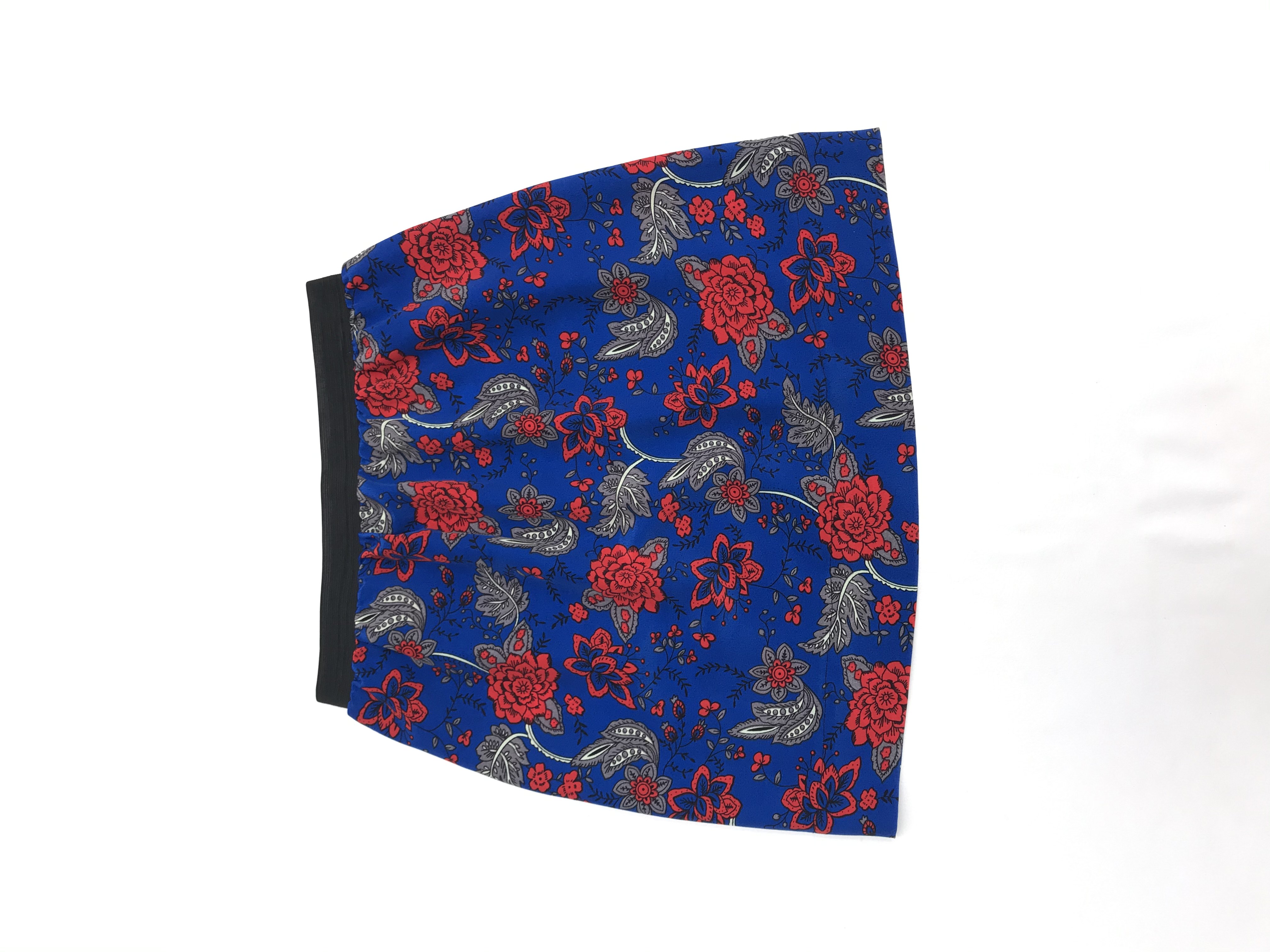 Falda azul con estampado de flores rojas y grises, tela plana tipo crepé, elástico negro en la cintura. Largo 46cm
Talla S