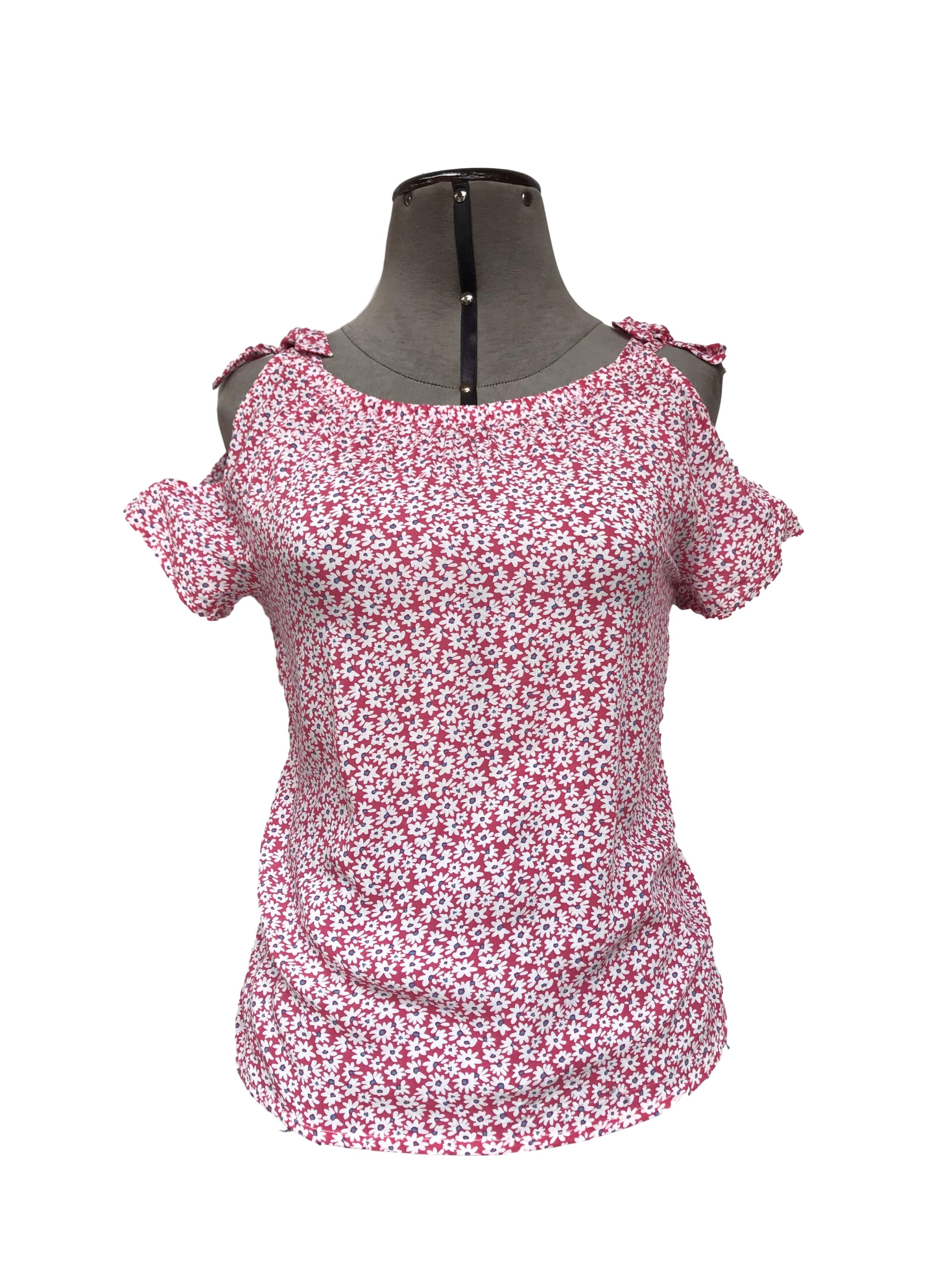 Blusa rosada con flores blancas, lazos y aberturas en los hombros
Talla XS