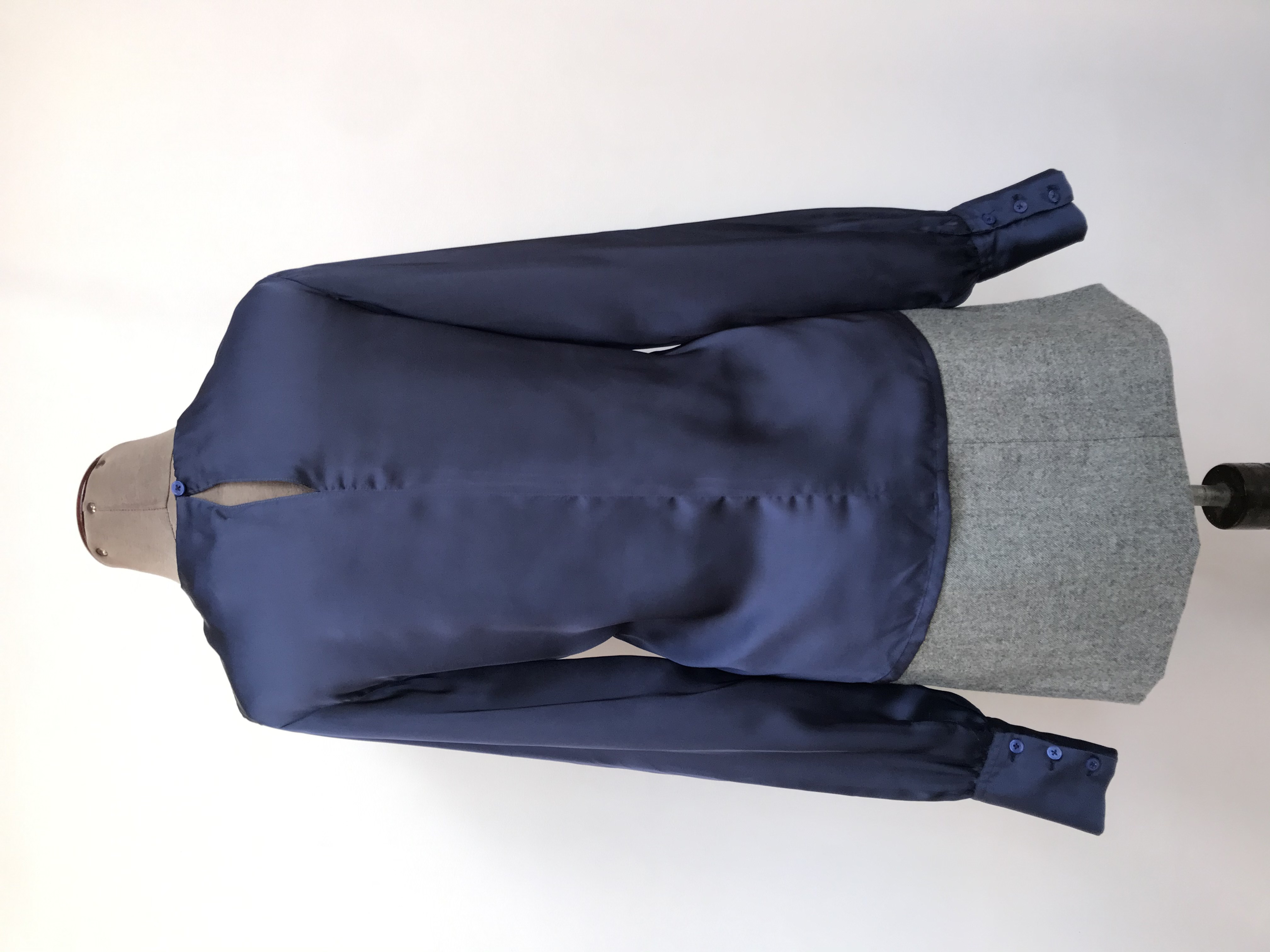 Blusa azul acero tipo seda con pliegues en el cuello, botón posterior, puños anchos con pliegues
Talla M