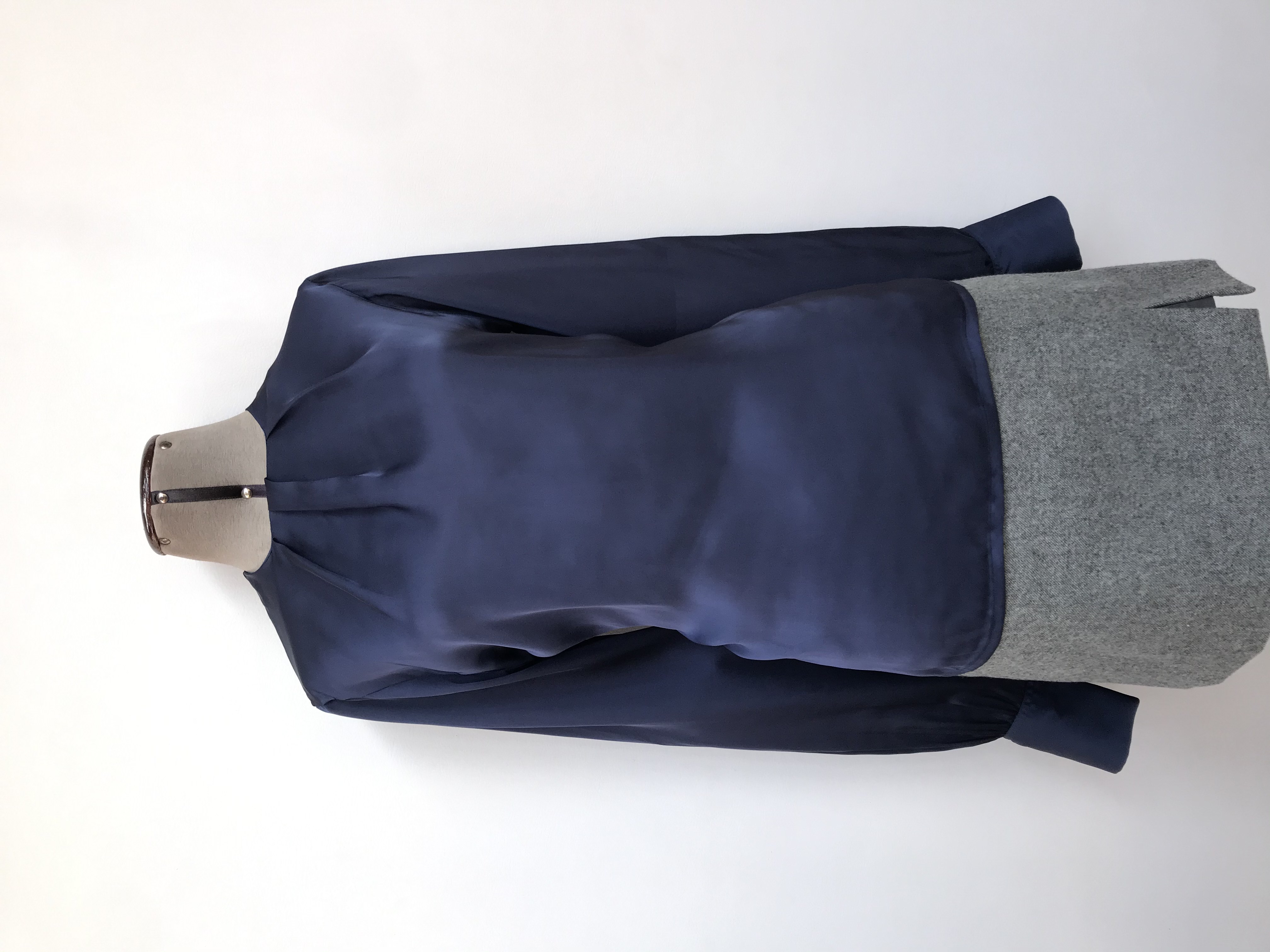 Blusa azul acero tipo seda con pliegues en el cuello, botón posterior, puños anchos con pliegues
Talla M