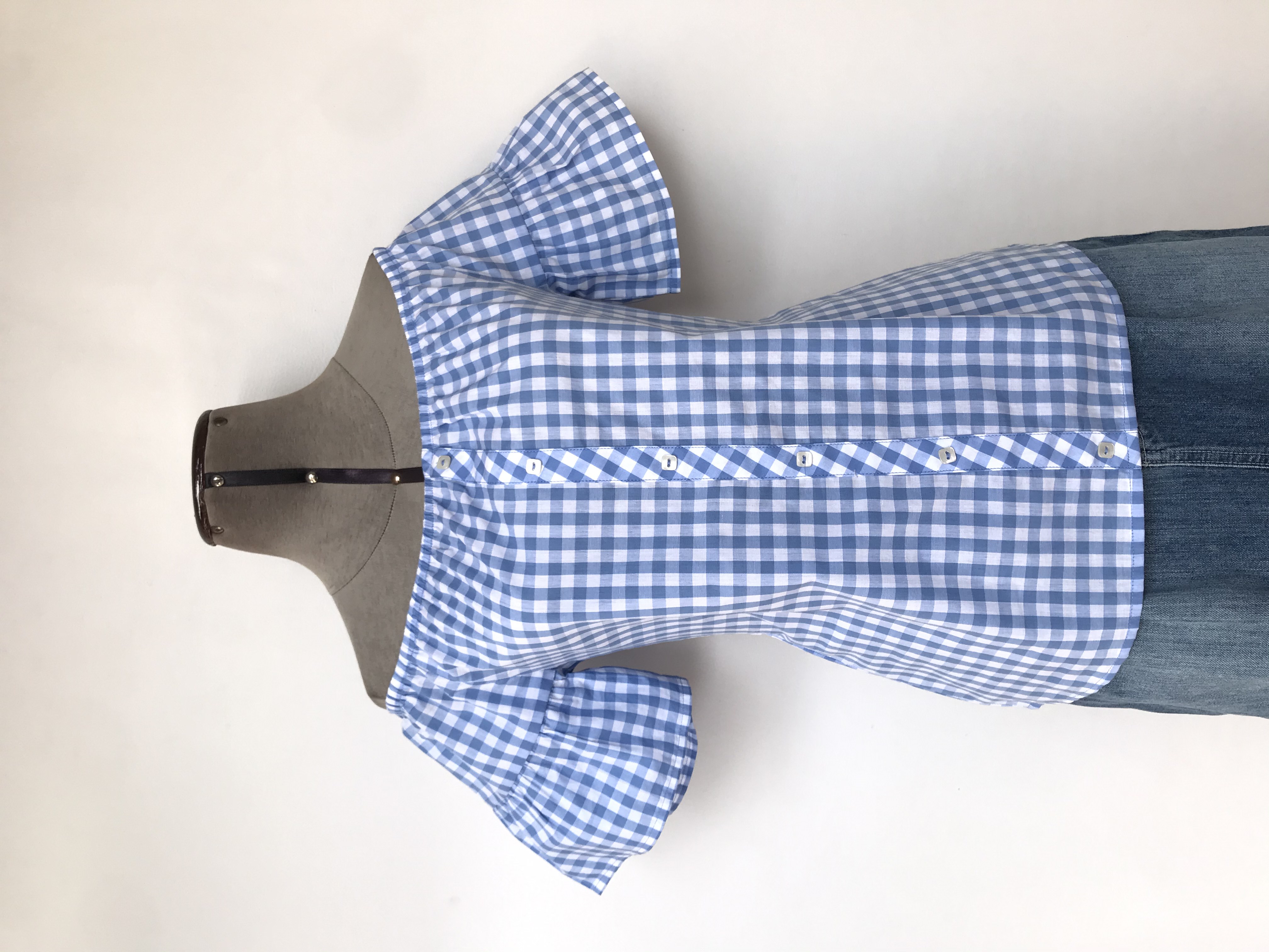 Blusa Pionier 100% algodón a cuadros celestes y blancos, off shoulder con elástico, fila de botones centrales y mangas con volante
Talla S