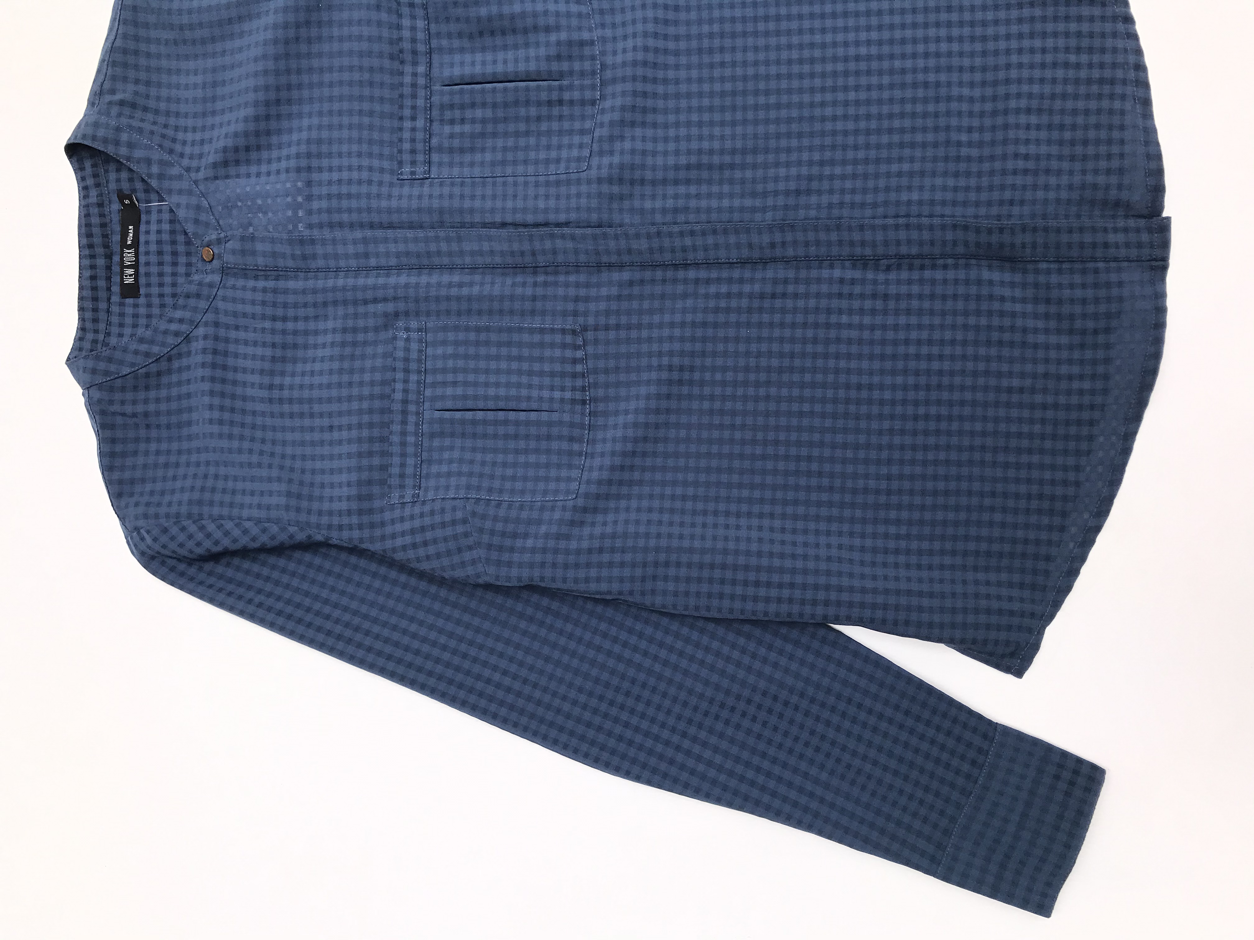 Blusa de cuadros en tonos azules, tela plana, fila de botones y bolsillos delanteros