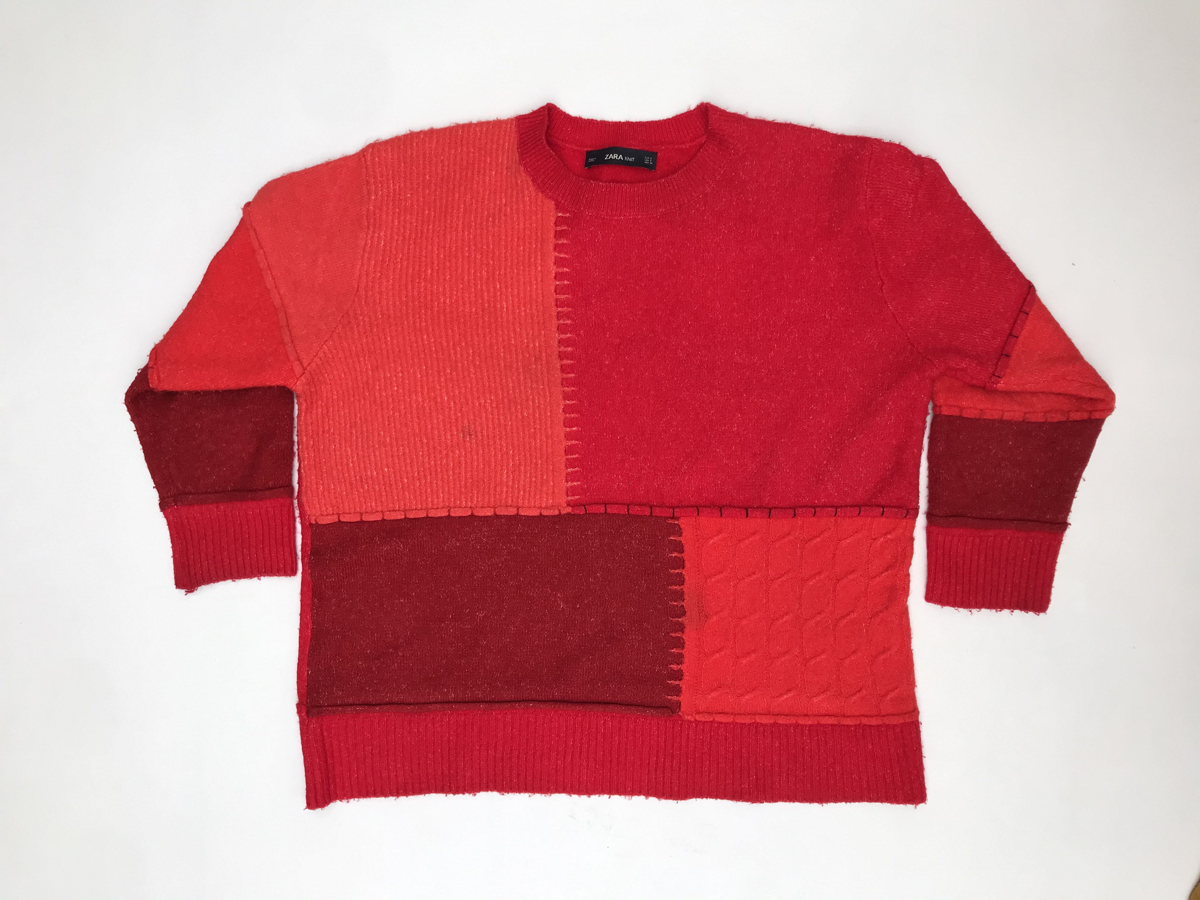 Chompa Zara oversized en tonos rojos estilo patchwork, es larga bajo la cadera y ancha. ¡Abriga! Precio original S/ 200
