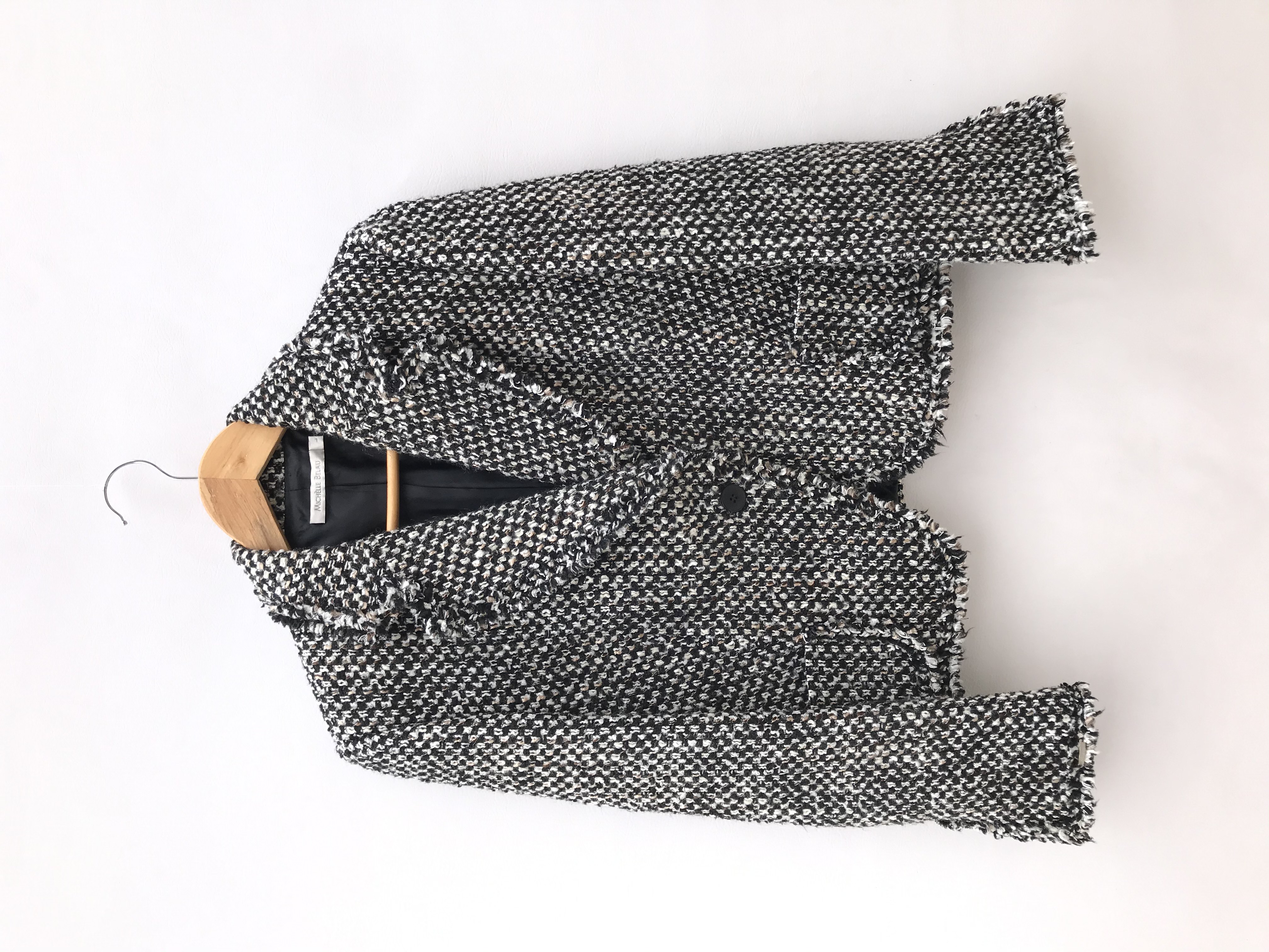 Abrigo Michelle Belau tipo tweed en tonos crema, negro y marrón, forrado, de un solo botón y bolsillos delanteros. Precio original S/ 350
