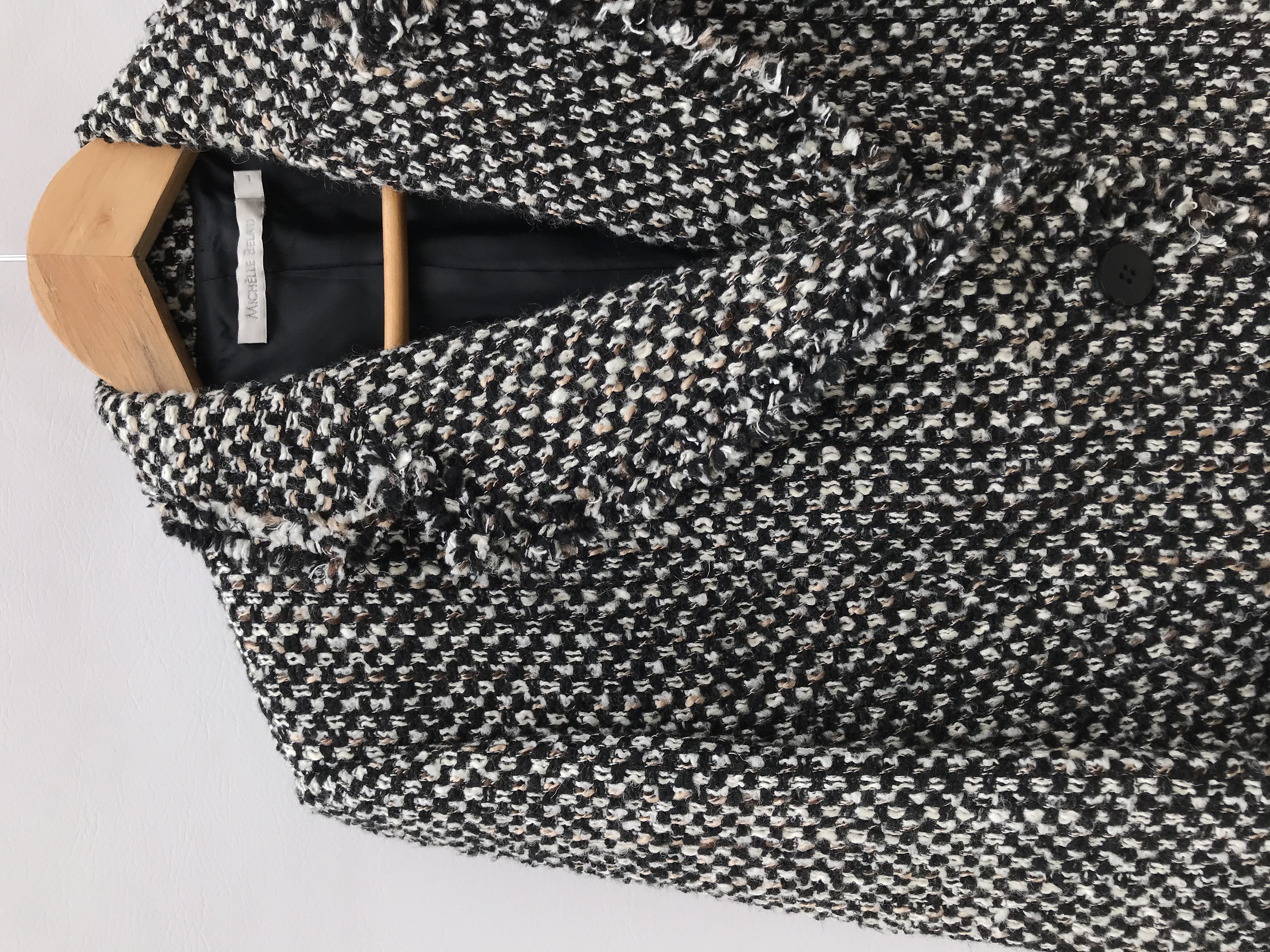Abrigo Michelle Belau tipo tweed en tonos crema, negro y marrón, forrado, de un solo botón y bolsillos delanteros. Precio original S/ 350