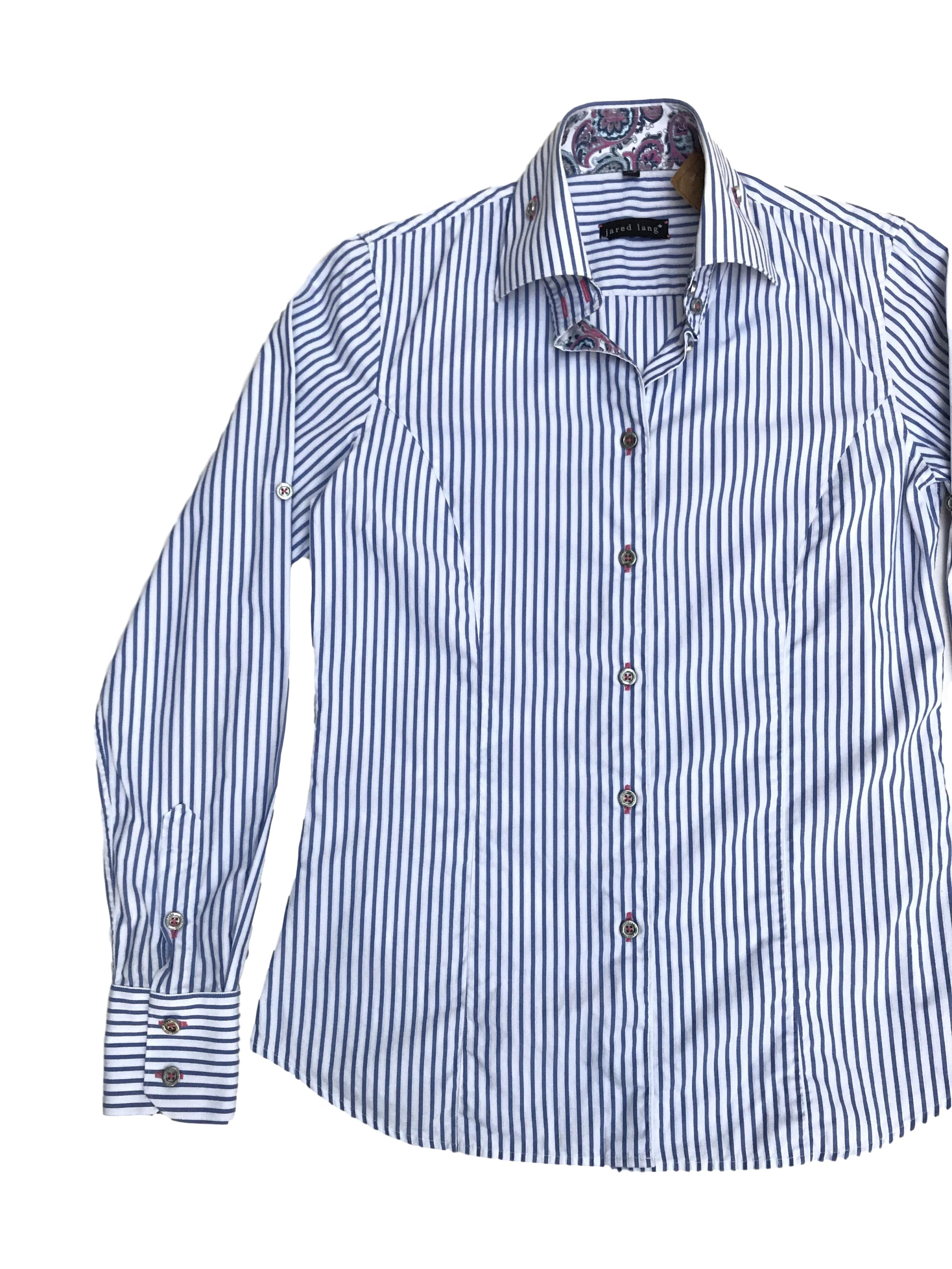 Blusa Jared Lang 100% algodón blanca con rayas celestes, botones plateados y detalle de tela paisley en puños y cuello. La que todas necesitamos en el closet con detalles especiales. Precio original S/ 200
