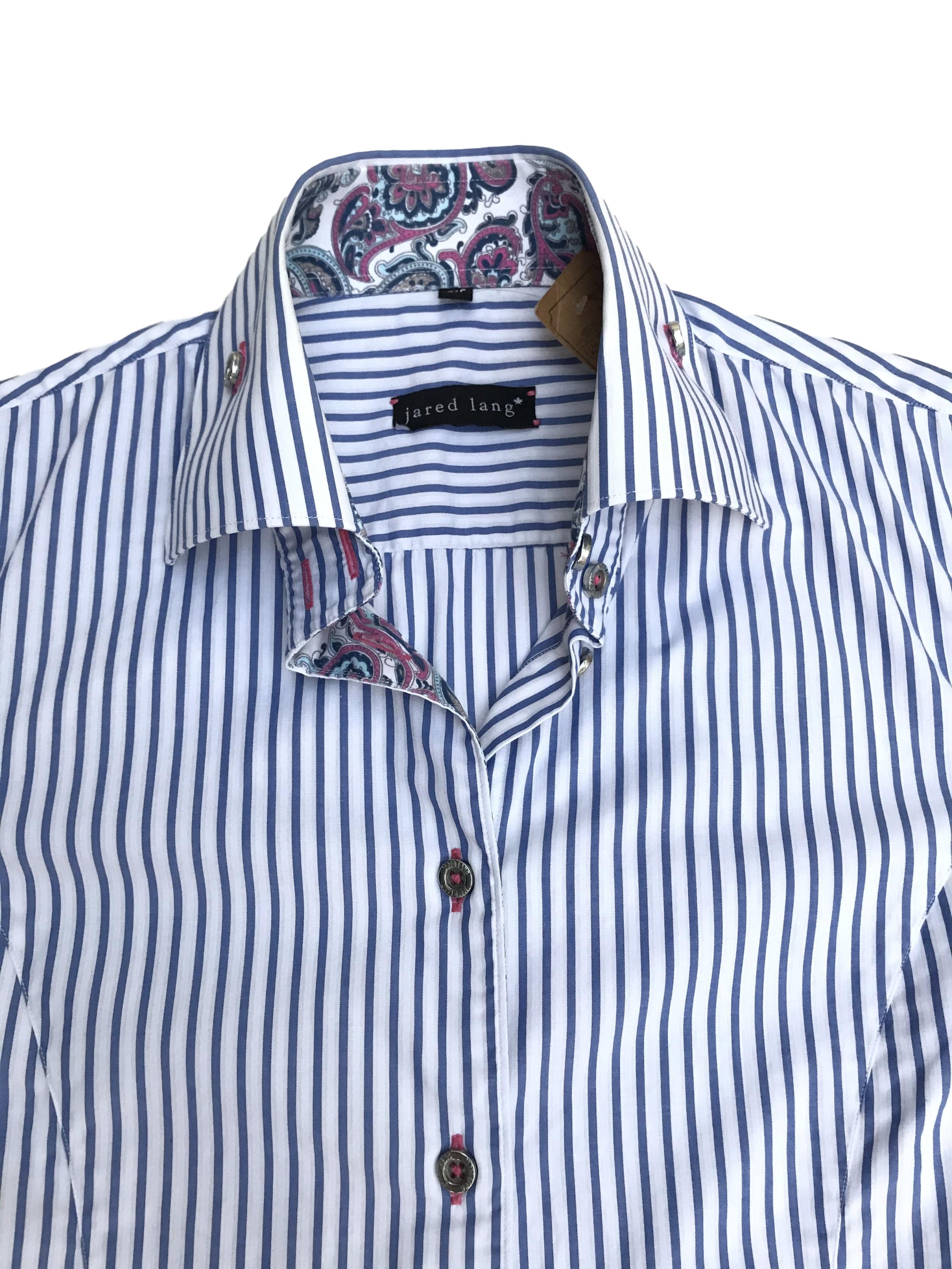 Blusa Jared Lang 100% algodón blanca con rayas celestes, botones plateados y detalle de tela paisley en puños y cuello. La que todas necesitamos en el closet con detalles especiales. Precio original S/ 200