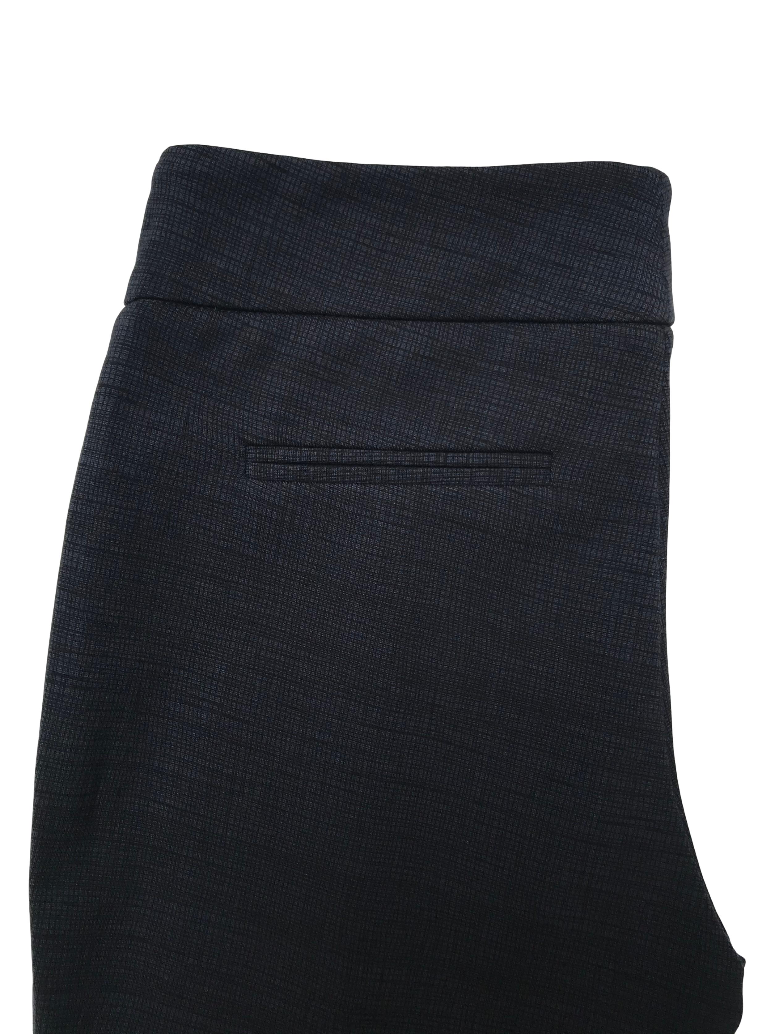 Legging stretch azul con líneas negras cruzadas, costura al medio de la pierna y bolsillos falsos atrás. Tiro medio pretina 76cm 