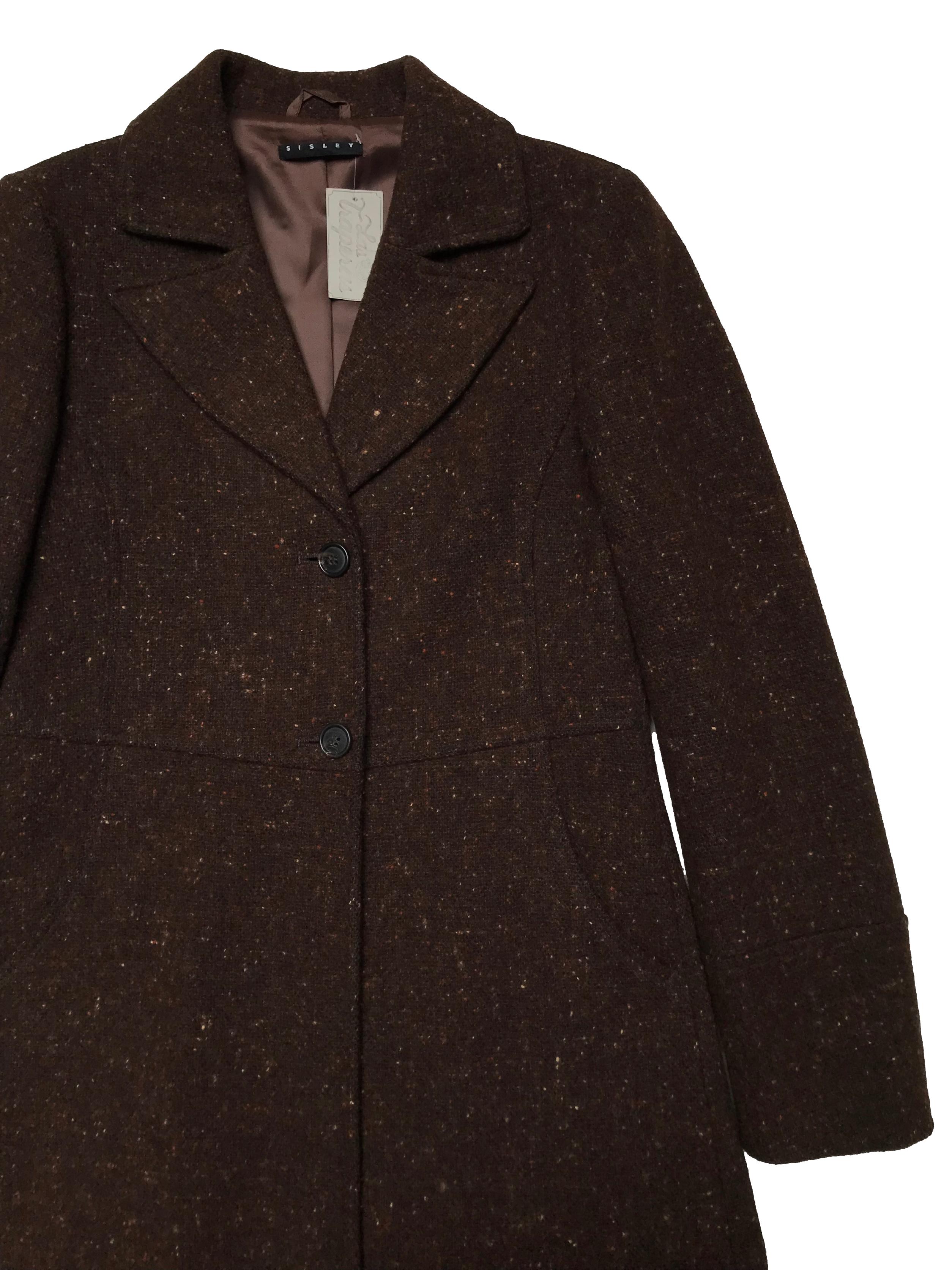 Abrigo Sisley marrón jaspeado, tela tipo lana compacta, forrado, tiene solapas, botones y bolsillos delanteros. Ancho 92cm Largo 95cm. Precio original S/ 700