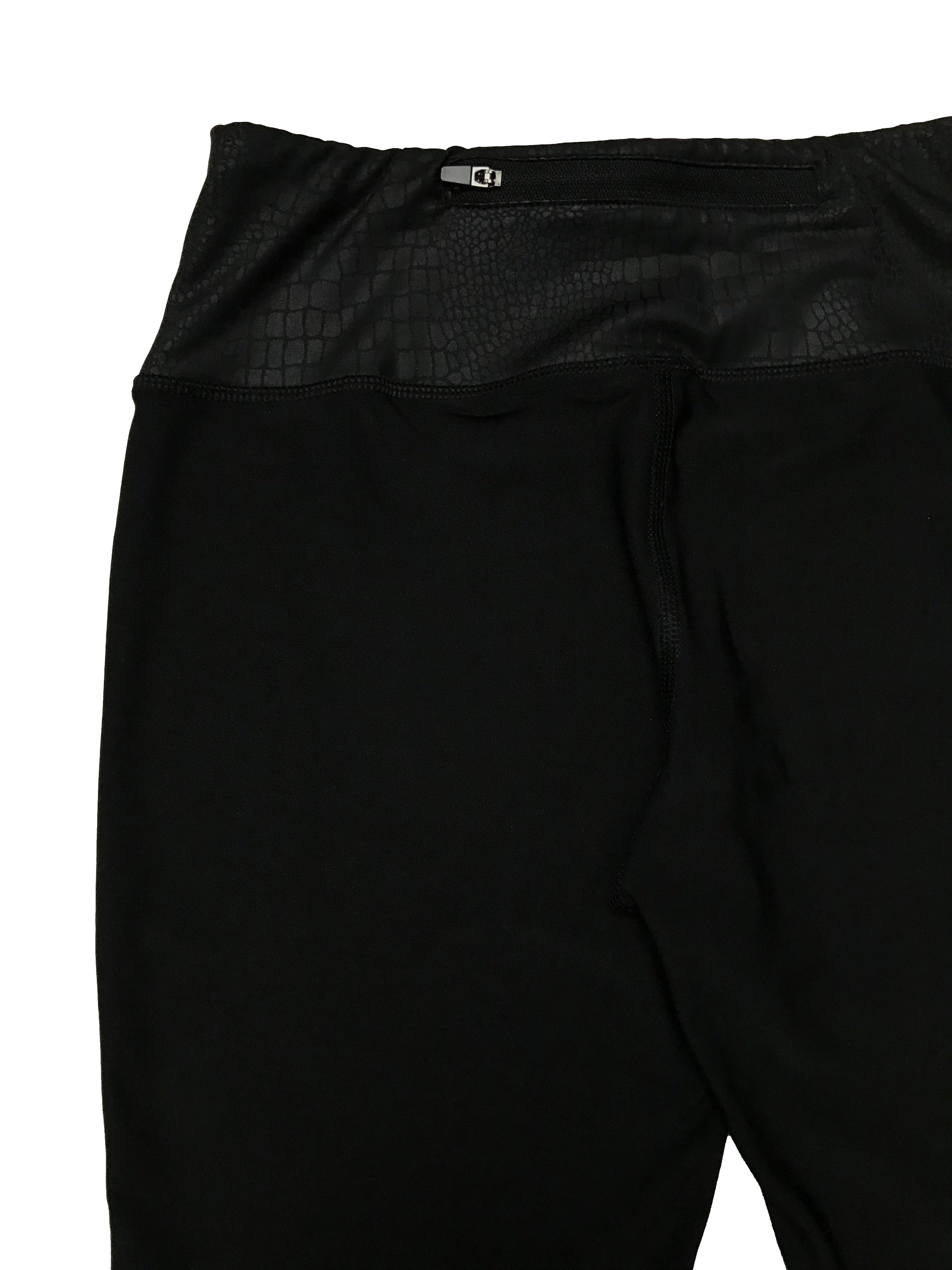Legging deportiva RBX, negra con detalles neón y textura pitón al tono, tiene un cierre posterior en la pretina, tiro medio. Largo 76cm Pretina 68cm sin estirar