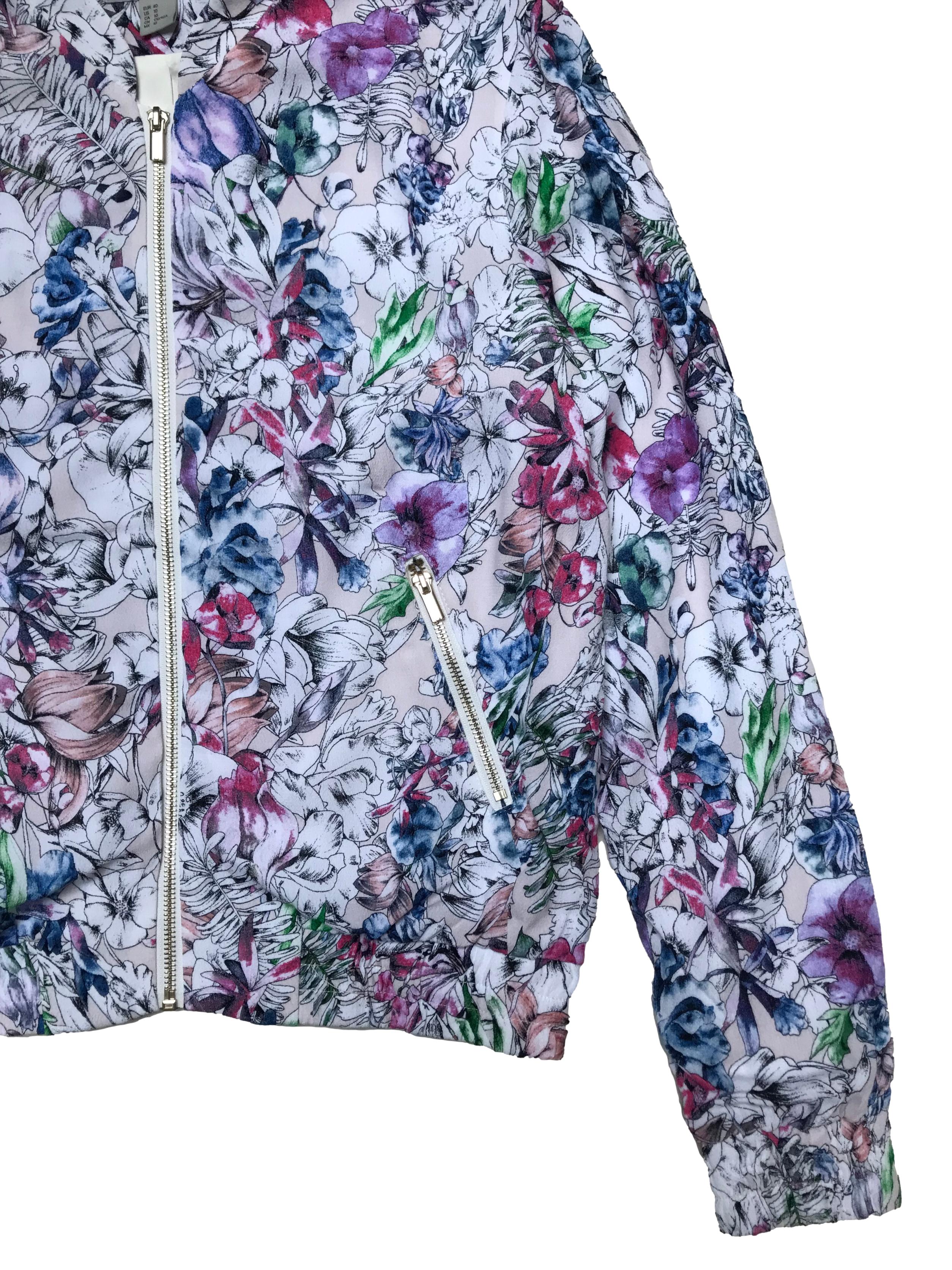 Casaca H&M estilo bomber jacket, blanca con estampado de flores, tiene forro, cierres delanteros y pretina en puños y basta.  Ancho 110cm Largo 57cm. Nueva. Precio original S/ 199