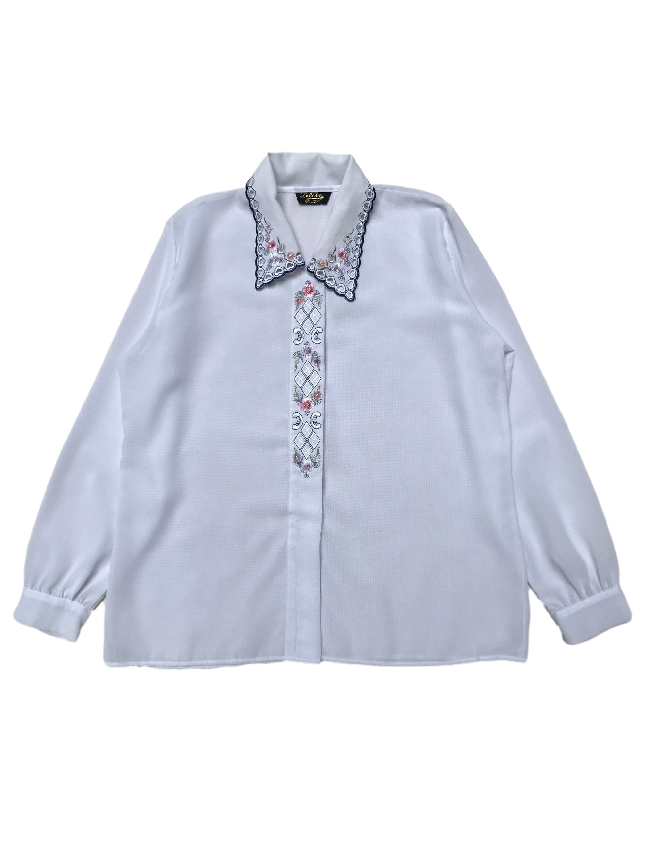 Blusa vintage de crepé blanco con detalles bordados y calados en cuello y tapa de botones. Ancho 110cm Largo 62cm