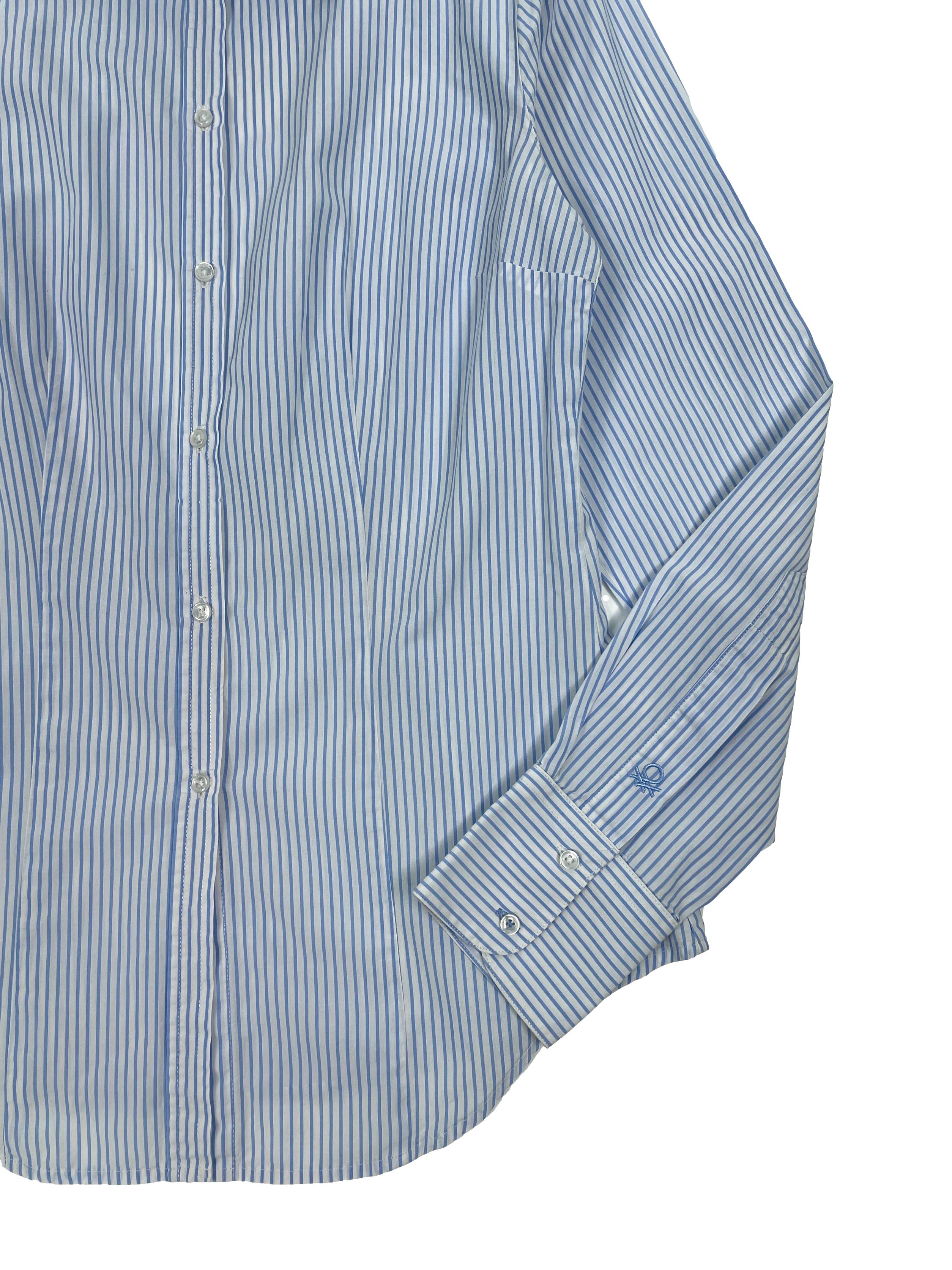  Blusa Benetton a rayas en blanco y celeste,  cuello camisero, pinzas frontales y posteriores, mangas largas y botón de repuesto.Busto 90cm, Largo 55cm.