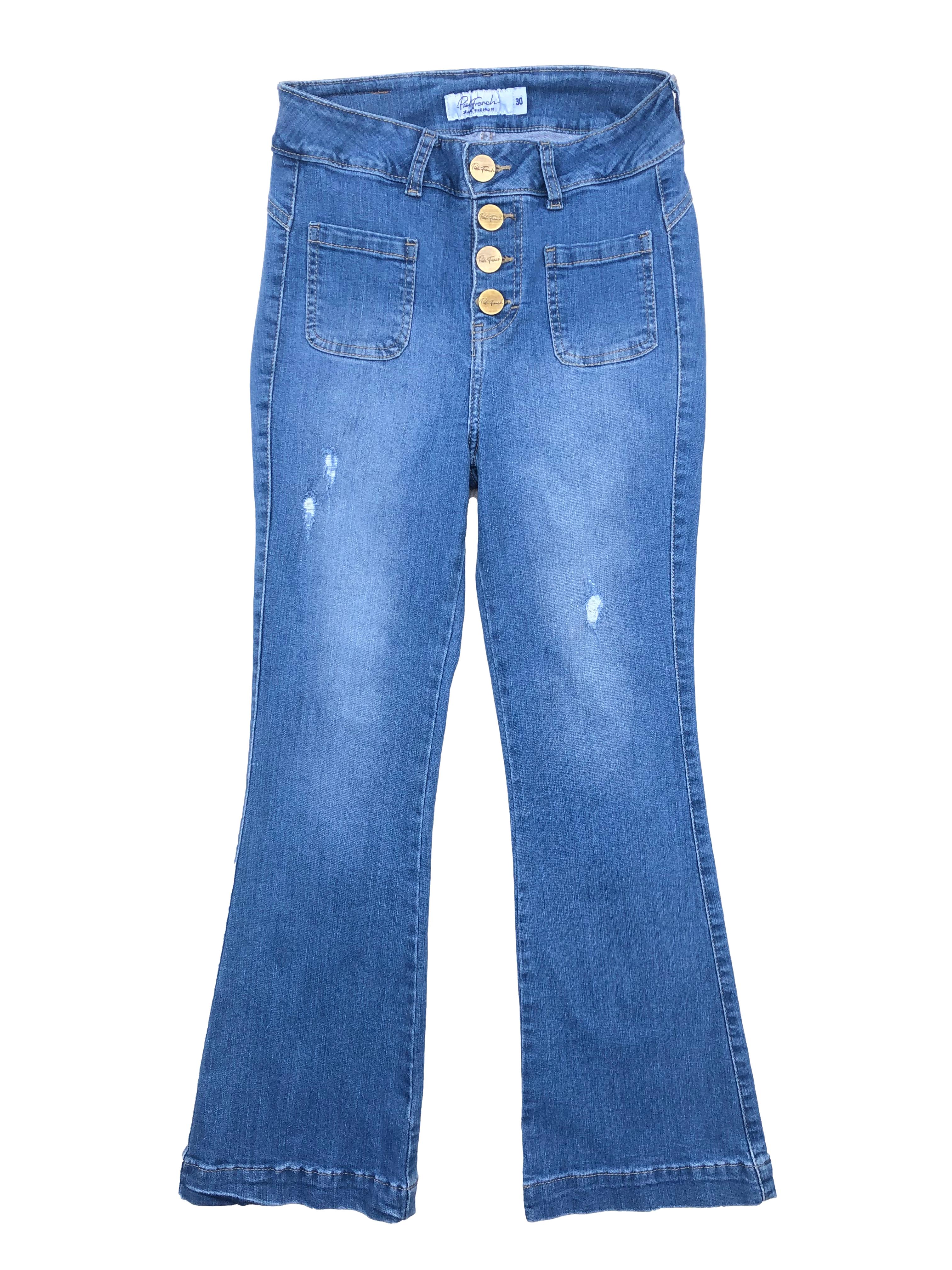 Jean azul Paola French, tela stretch con efecto lavado y rasgados, tiene bota campana, botones metálicos, cuatro bolsillos, y entalle posterior con pinzas. Cintura 64cm sin estirar, Largo 88cm.