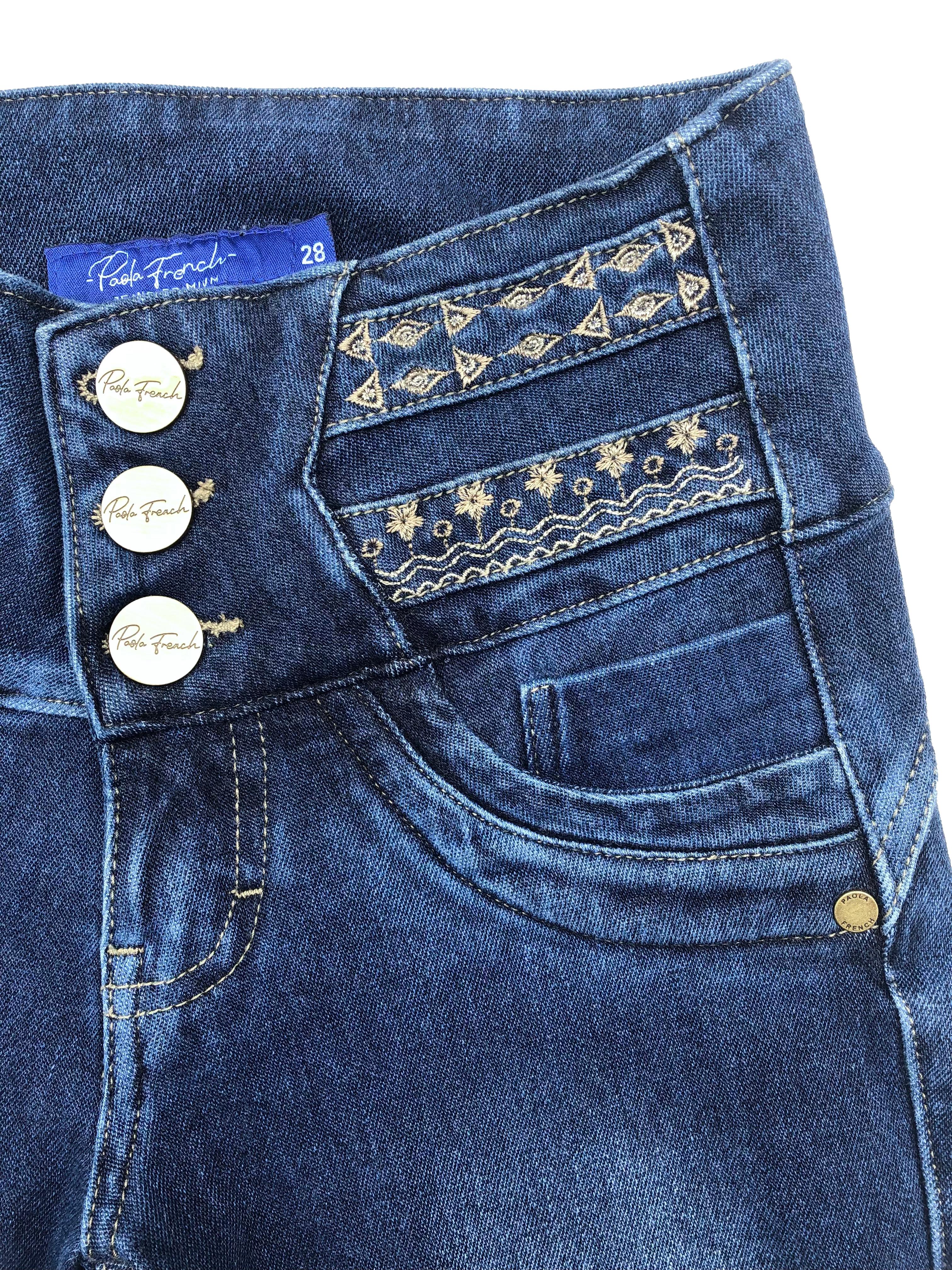 Skinny jean azul Paola French, tela stretch con focalizado, pretina ancha con bordado y botones metálicos, falsos bolsillos y entalle posterior con pinzas. Cintura 64cm sin estirar, Tiro 21.5cm, Largo 88cm.